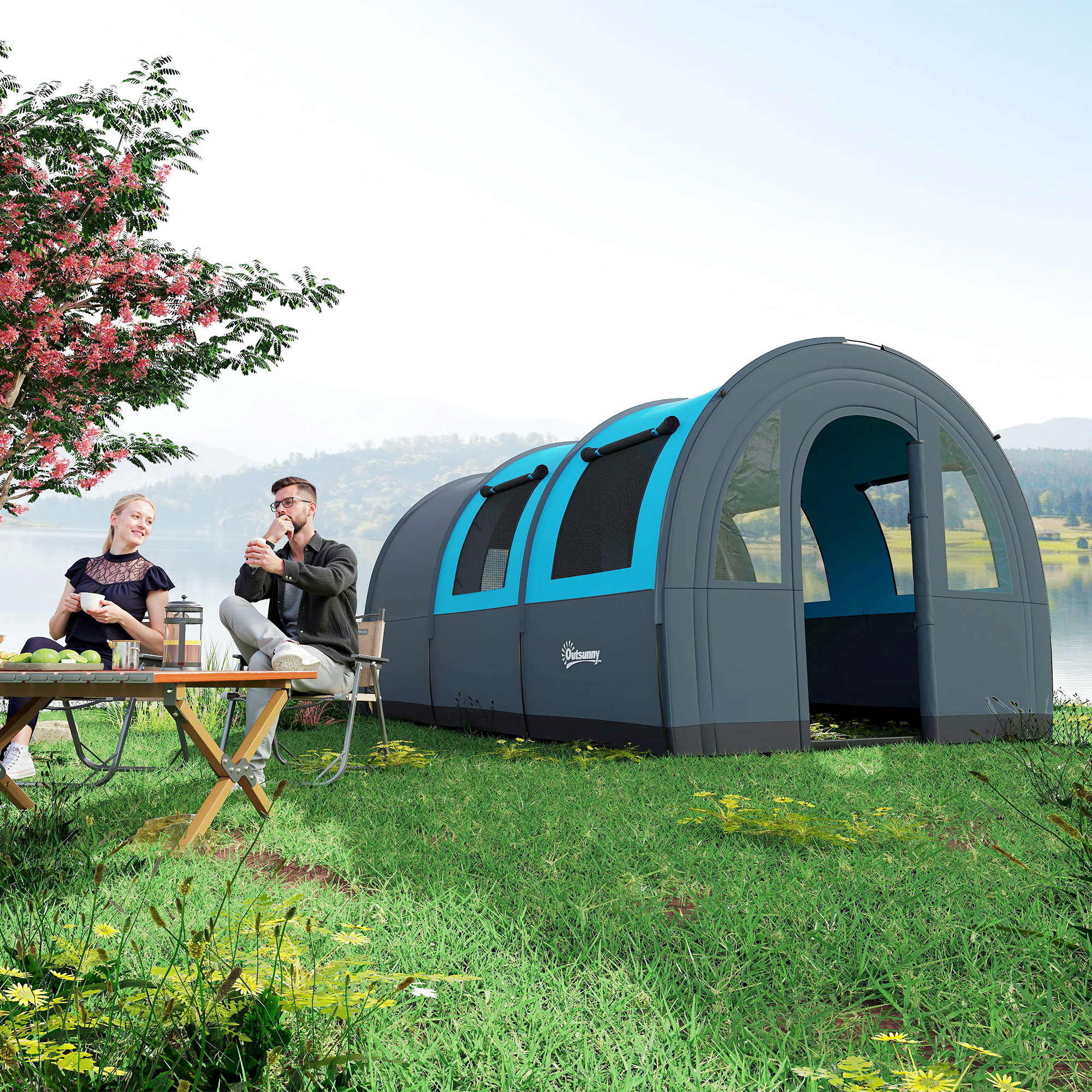 Una pareja disfruta de bebidas junto a un lago, junto a una carpa túnel y un árbol en flor.