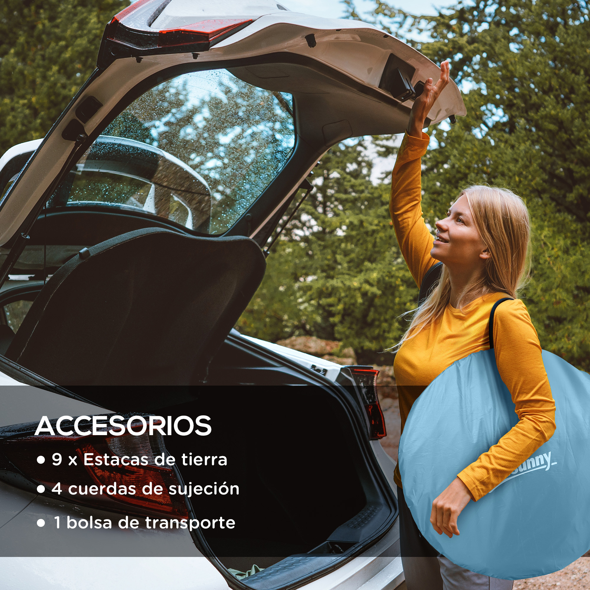 Una mujer carga una bolsa azul en un coche abierto con árboles al fondo.
