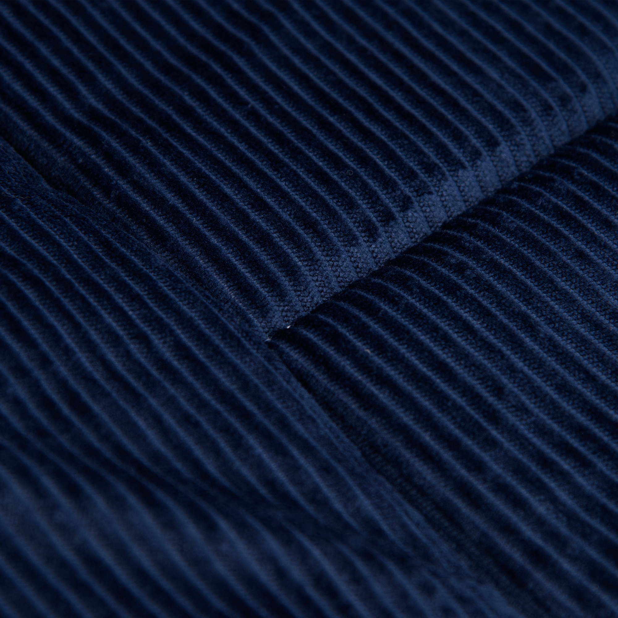 Tela de pana azul oscuro con costillas verticales y pliegues.