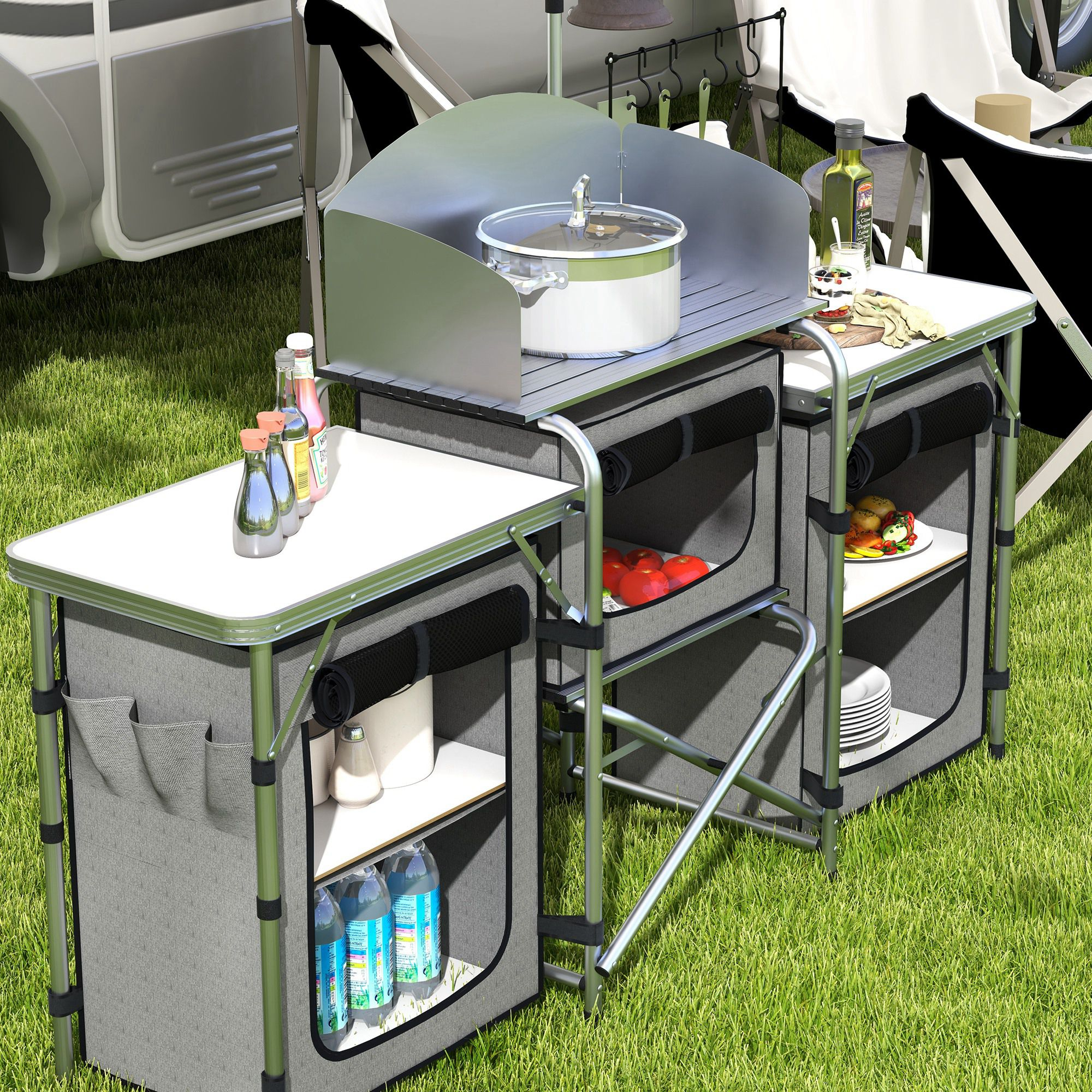 Cocina de camping exterior con olla, comida, botellas y platos.