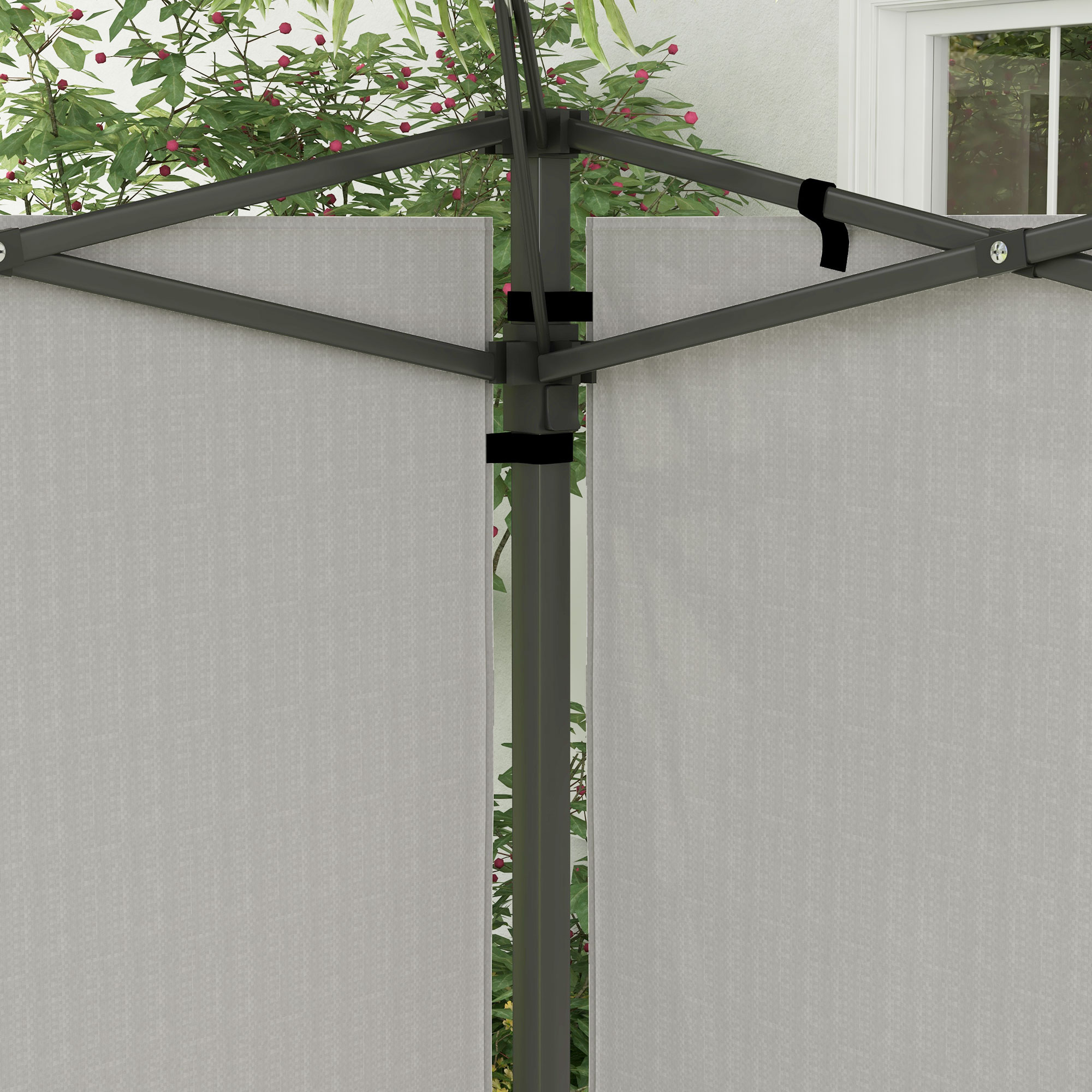 Estructura de toldo gris con paneles de tela y hojas verdes con bayas rojas al fondo.