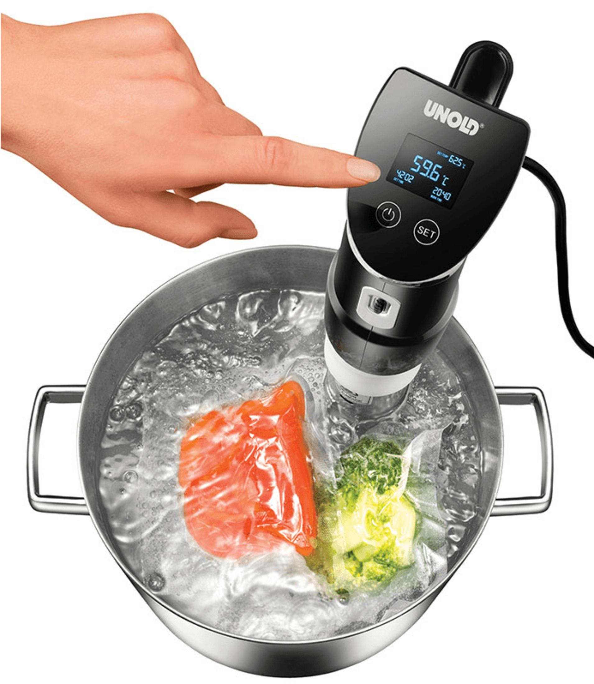 Ein Finger berührt ein Sous-Vide-Gerät in einem Topf mit kochendem Wasser und Lebensmitteln.