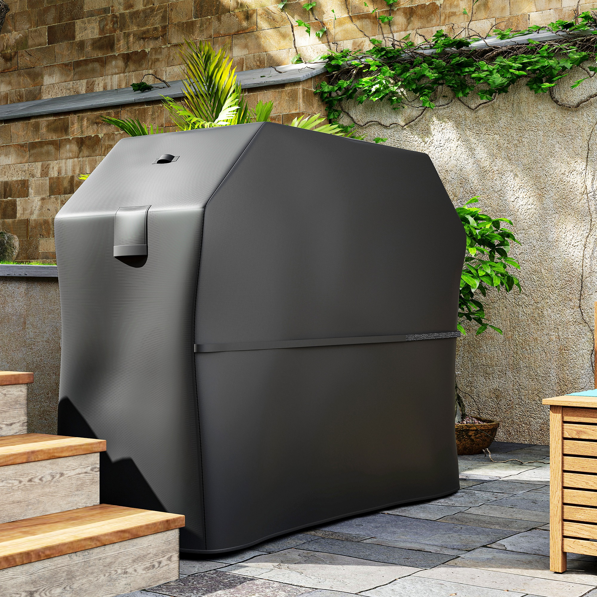 Una copertura per grill nera si trova su un patio di piastrelle di pietra vicino a gradini di legno.