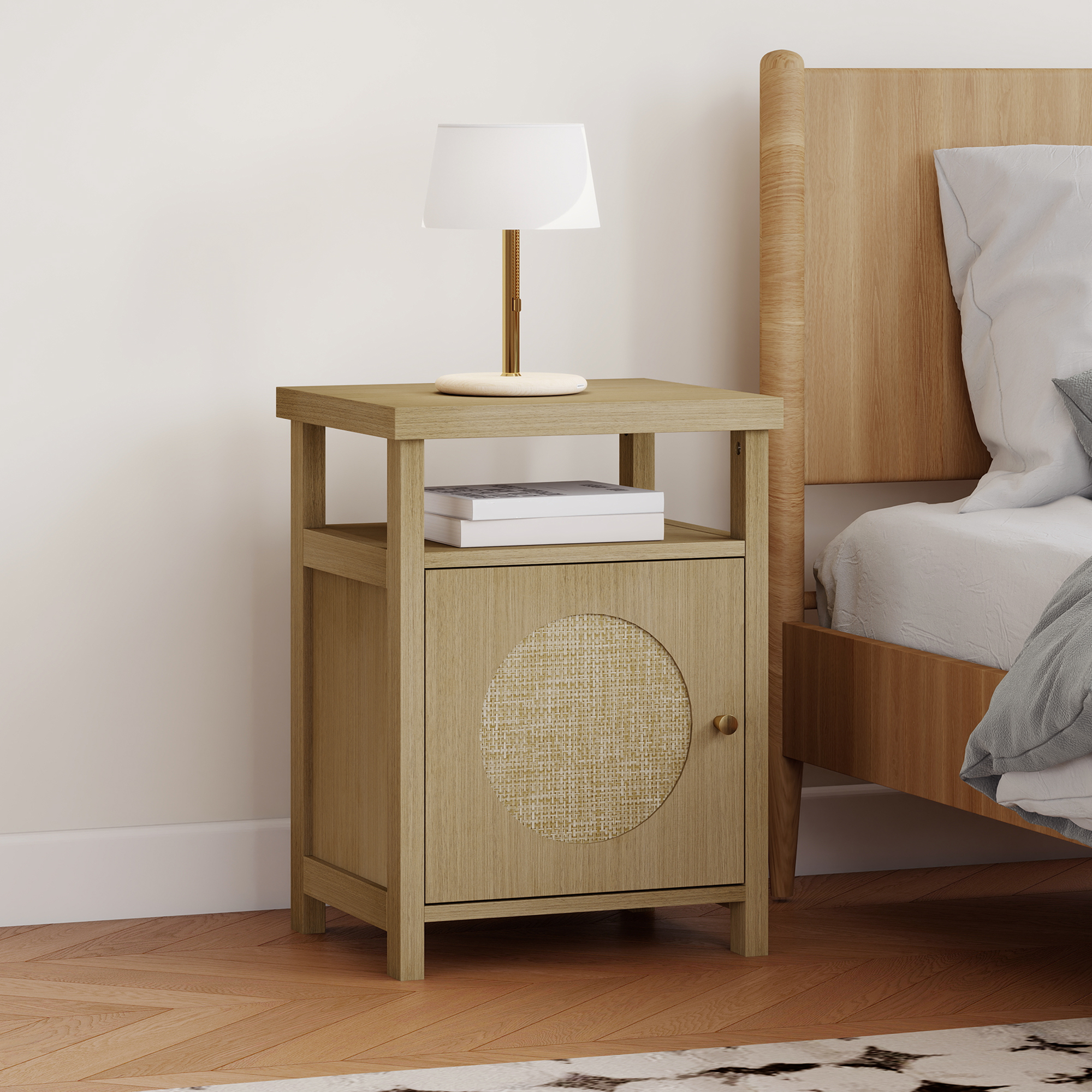 Mesita de noche de madera con lámpara, libros y puerta de ratán junto a cama.