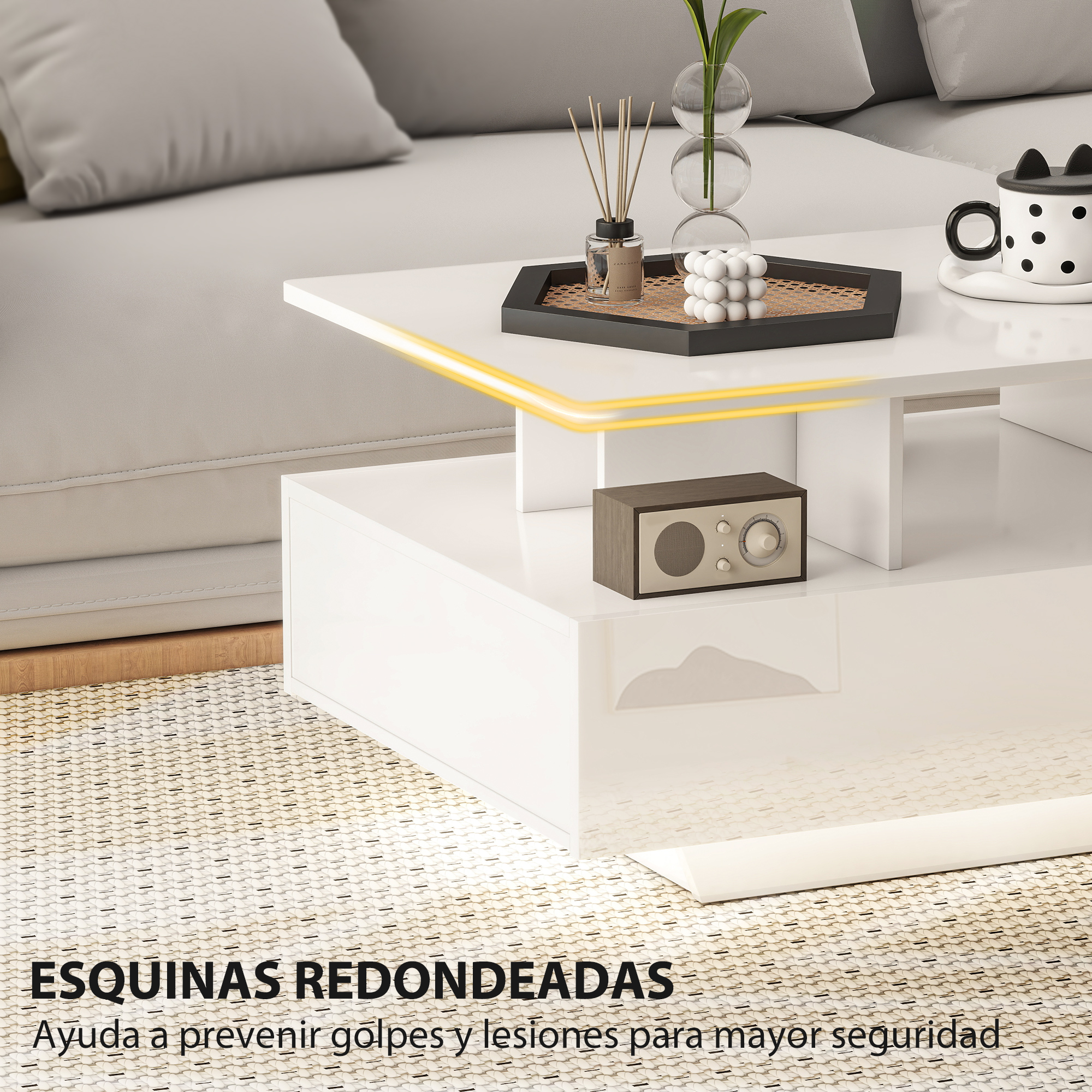 Una mesa de centro blanca moderna con radio, difusor y taza.