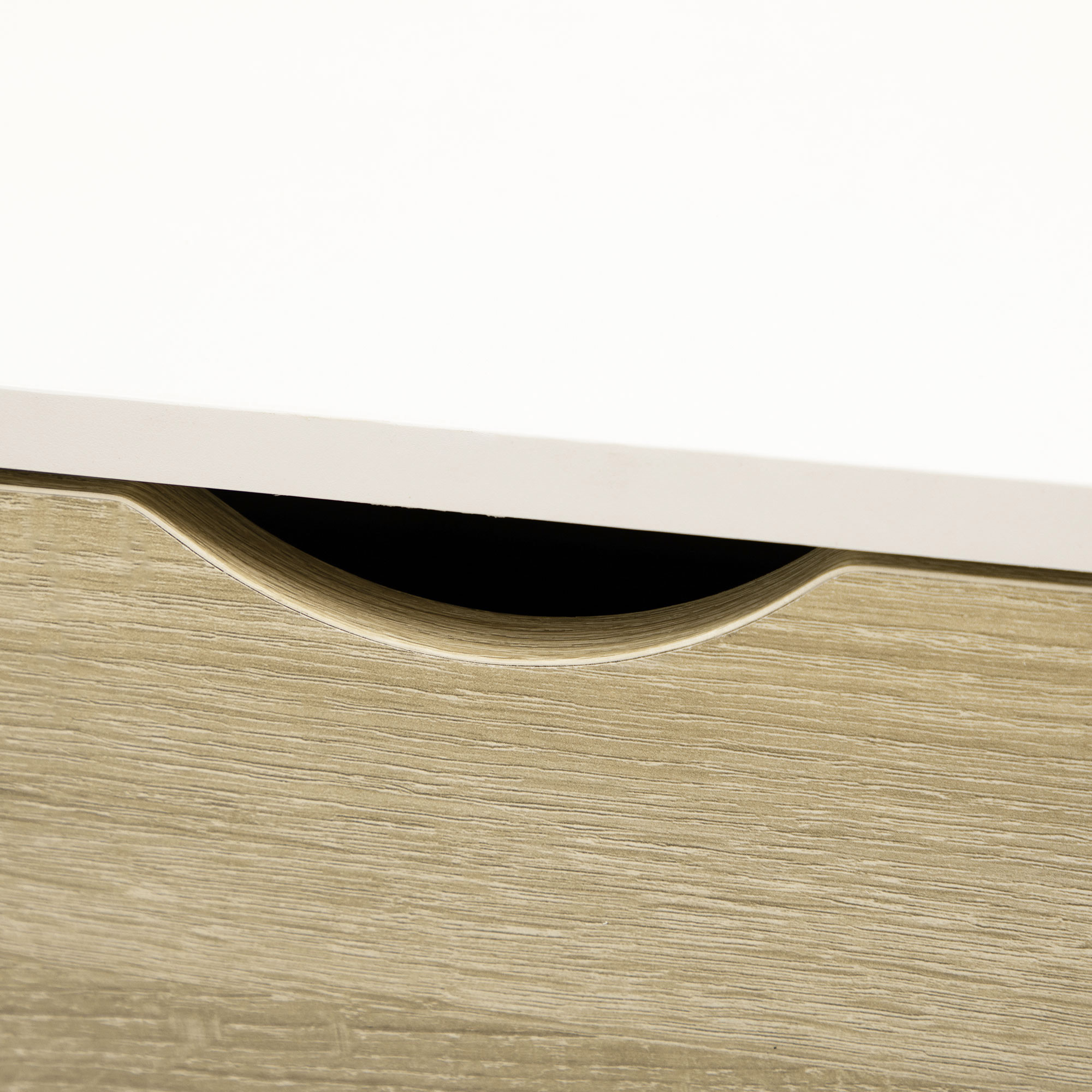 Frente de cajón con veta de madera bajo una superficie blanca.