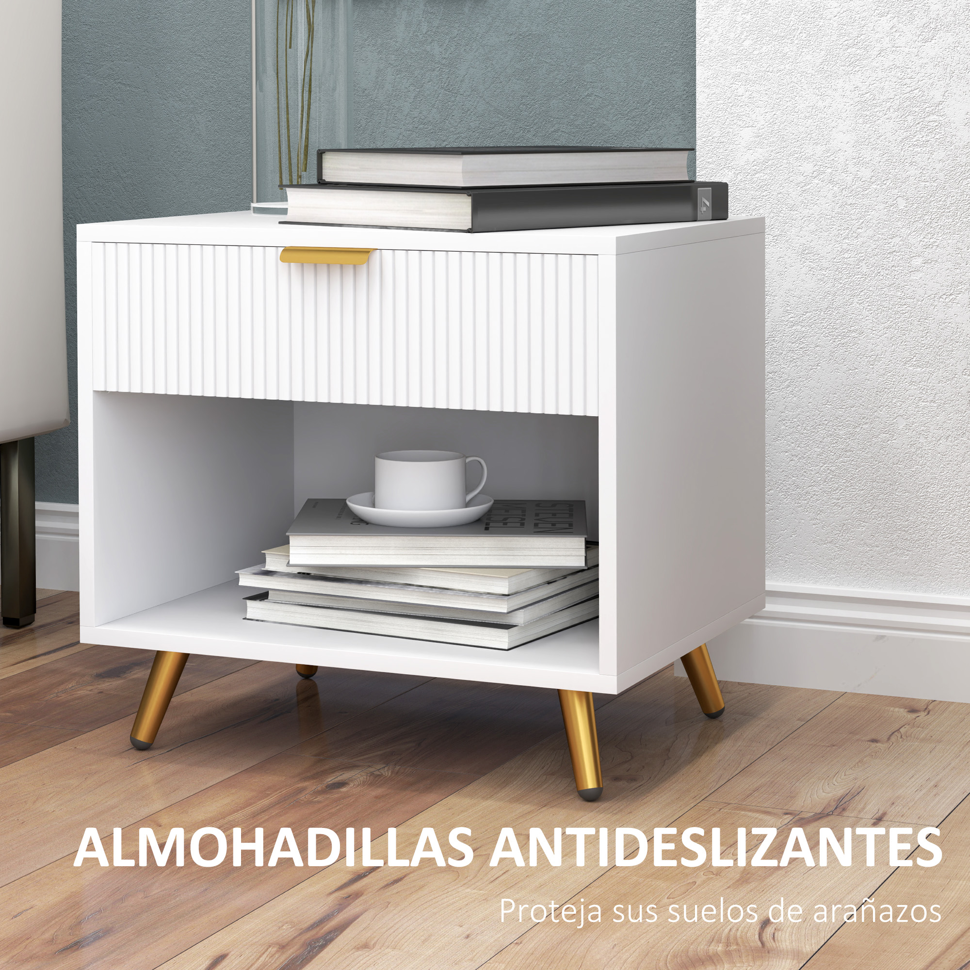 Una mesita de noche blanca con patas doradas, libros y una taza.