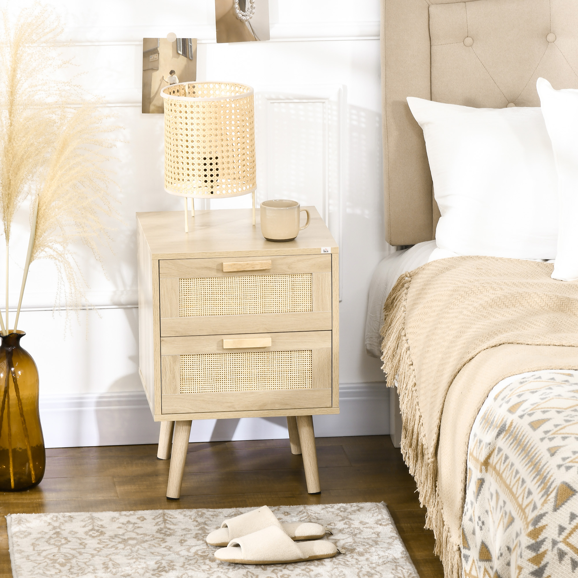 Una mesita de noche de madera con puertas de ratán junto a una cama con manta beige.