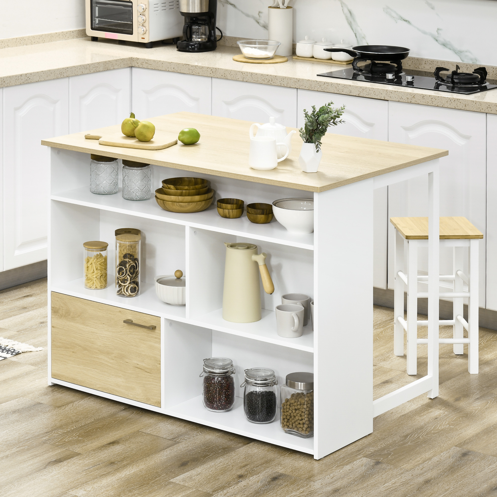 Una isla de cocina blanca con tapa de madera, llena de suministros, un taburete al lado.