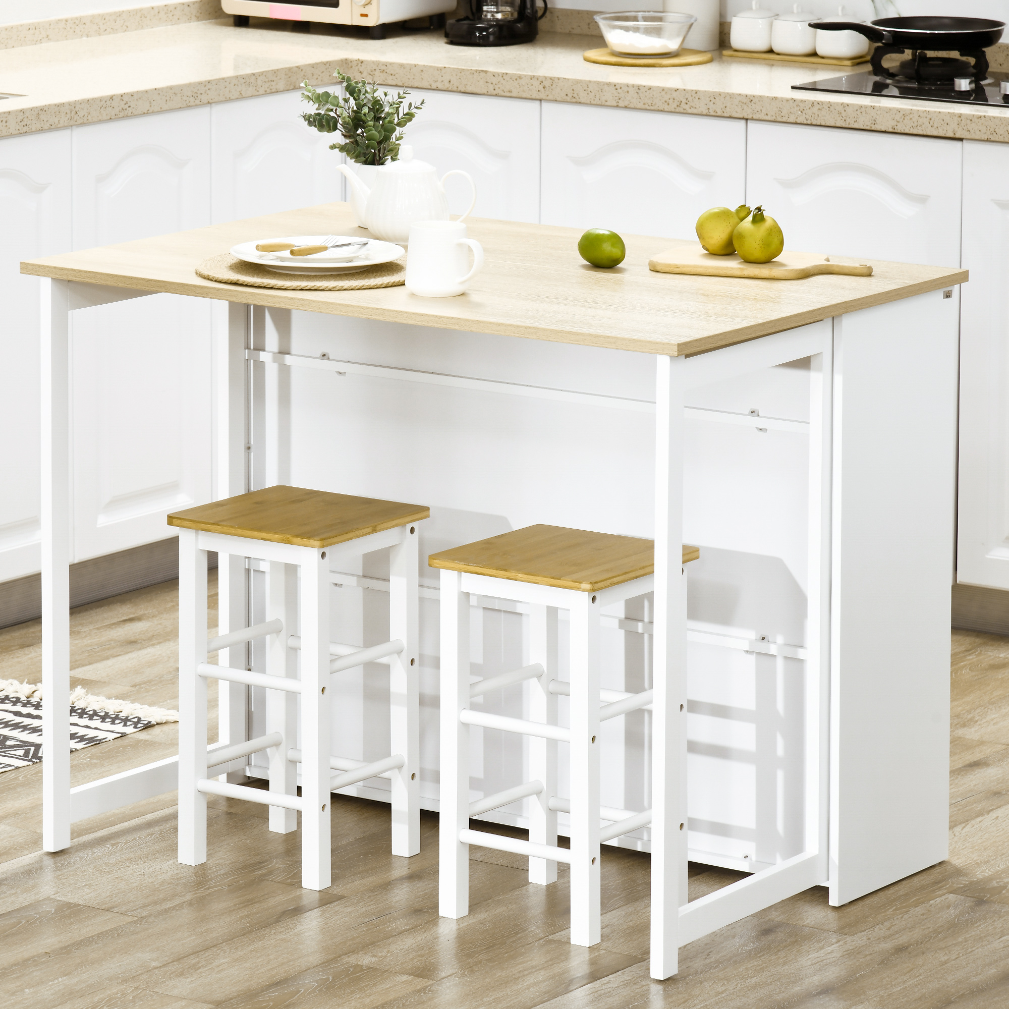 Una mesa de cocina clara con dos taburetes, decorada con frutas y vajilla.