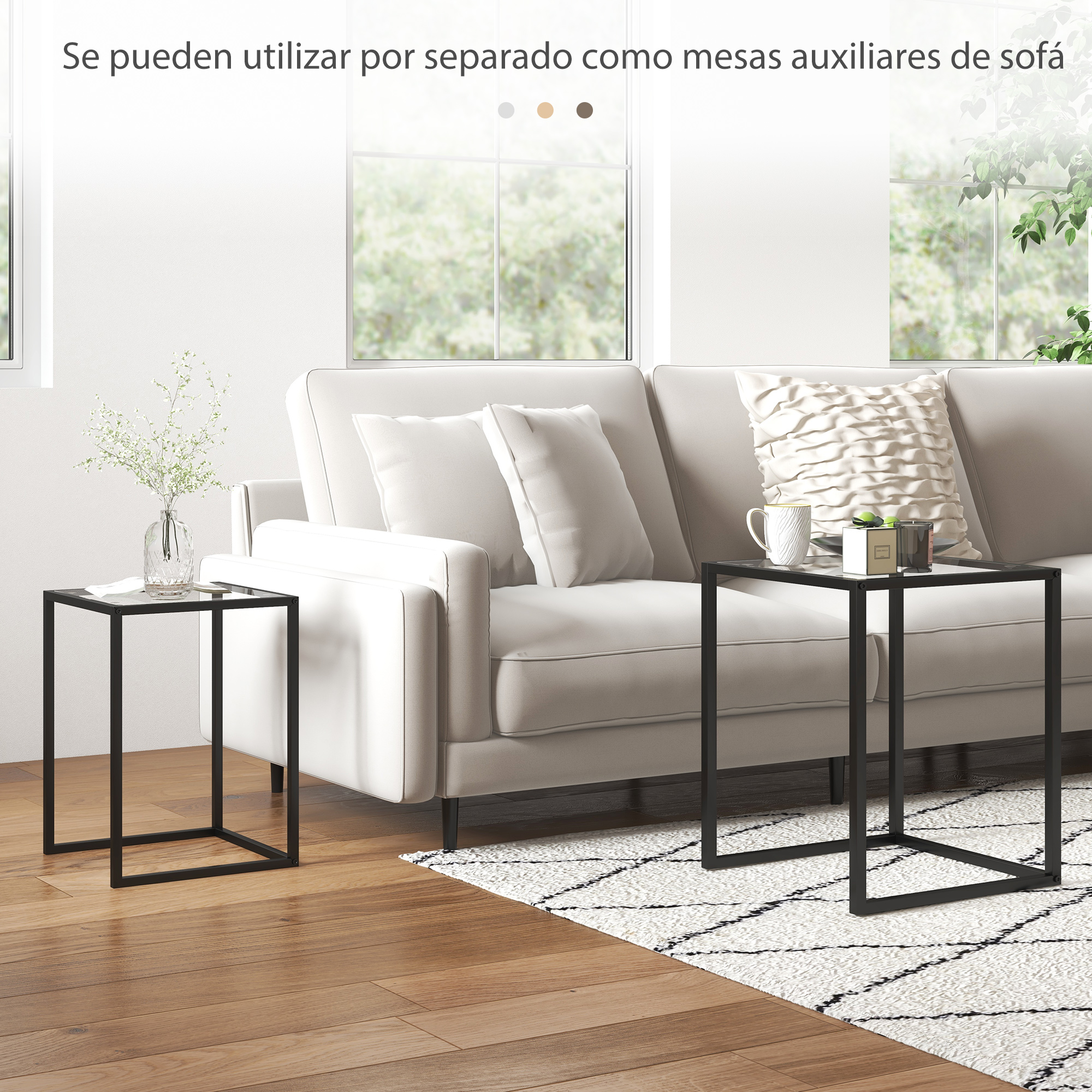 Dos mesas auxiliares modernas de metal negro con tapa de cristal junto a un sofá.