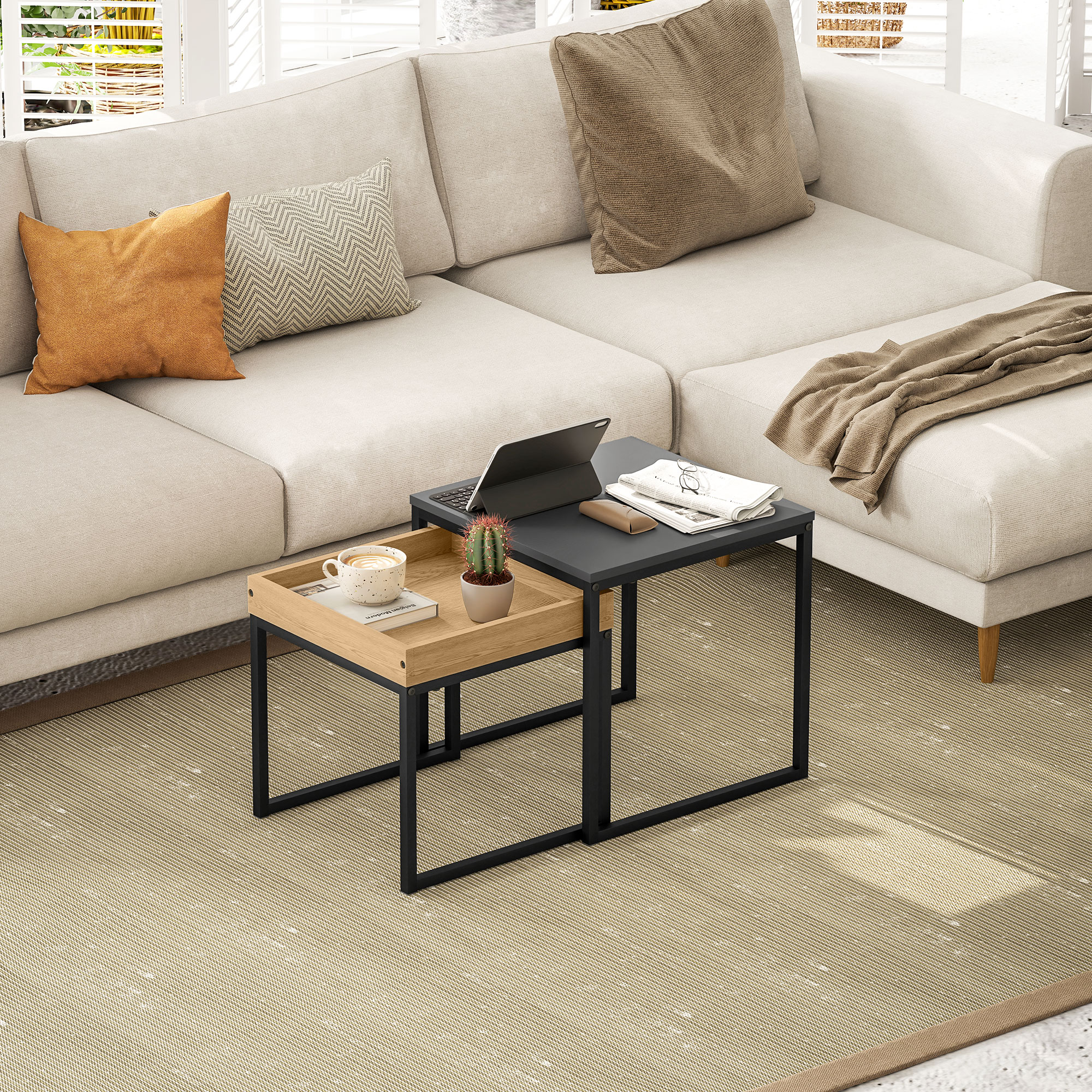 Un sofá beige con cojines y una mesa auxiliar con portátil, café y cactus.