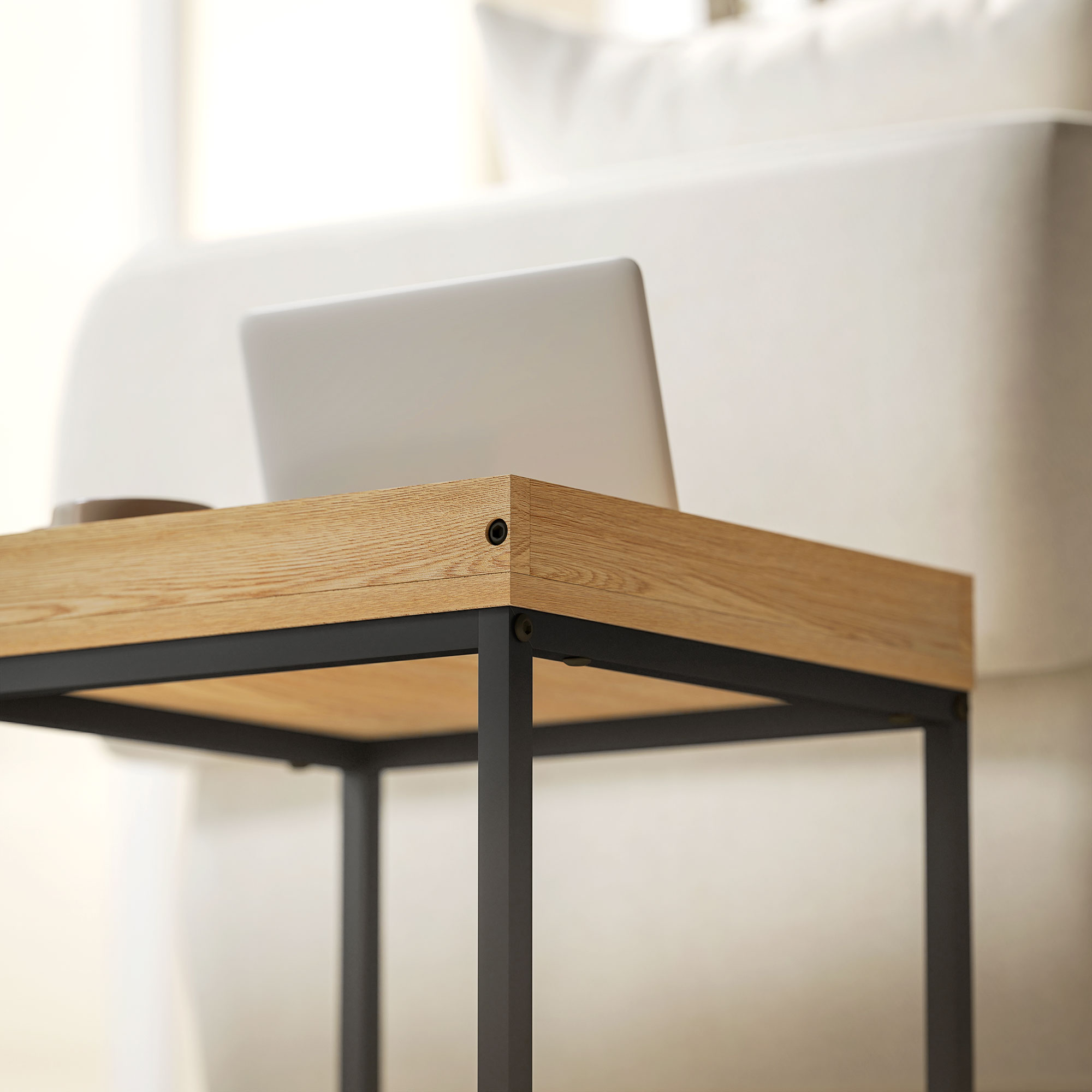 Un portátil sobre una mesa de madera con marco de metal negro.