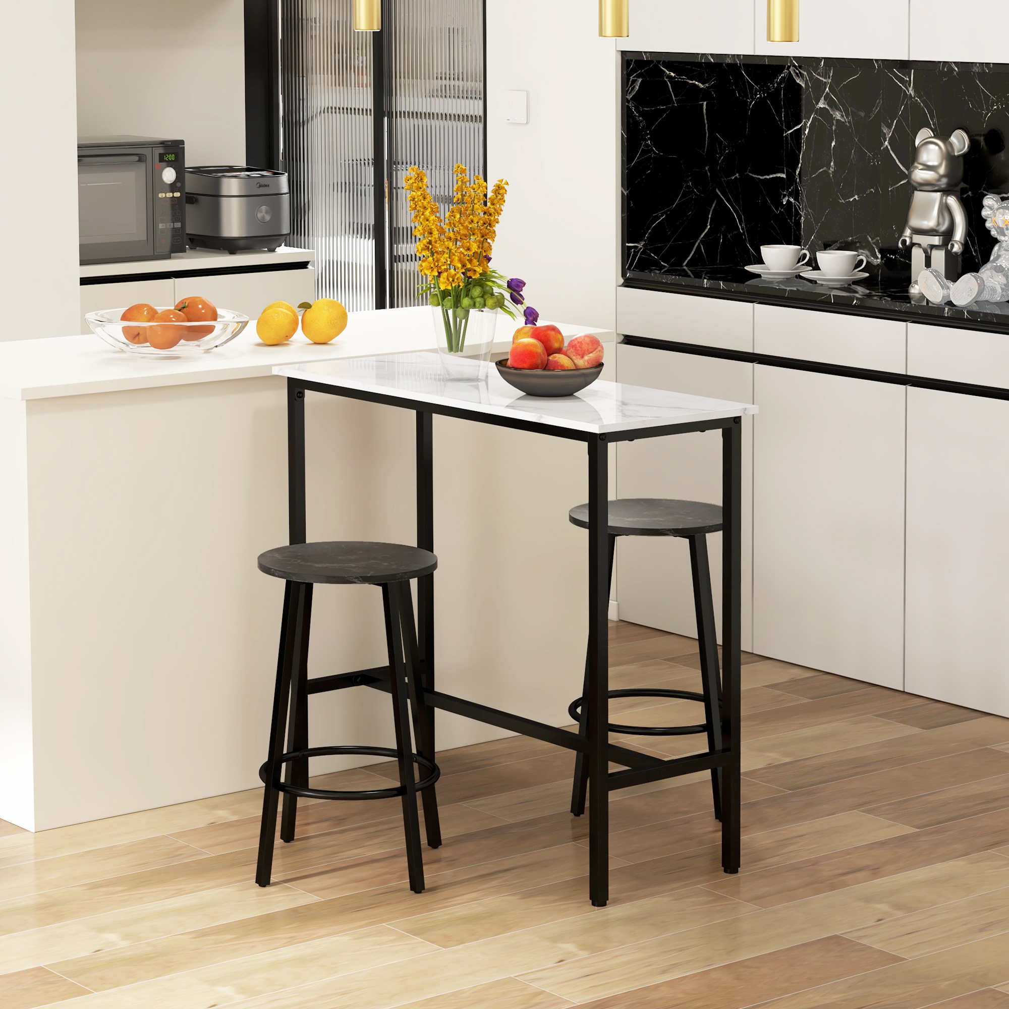 Mostrador de cocina con dos taburetes, fruteros, microondas y decoración.