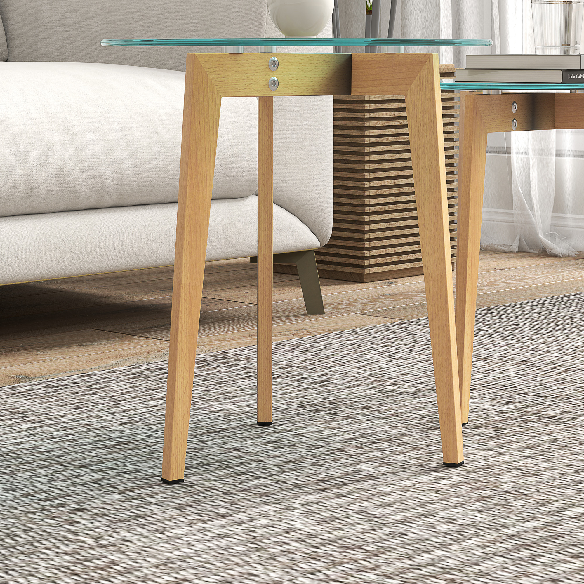 Mesa de cristal con patas de madera sobre alfombra junto a sofá.