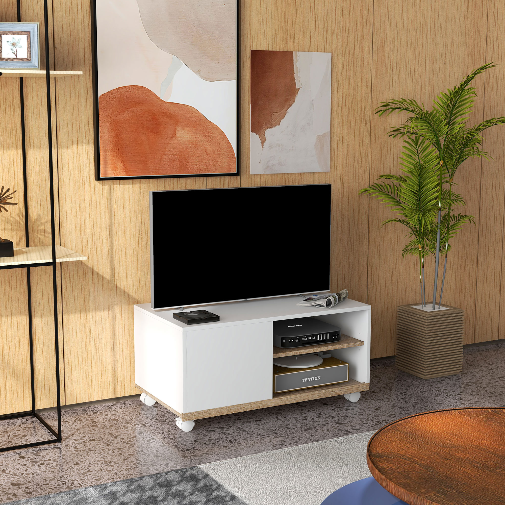 Un televisor está sobre un mueble blanco y de madera. Hay cuadros colgados en la pared.