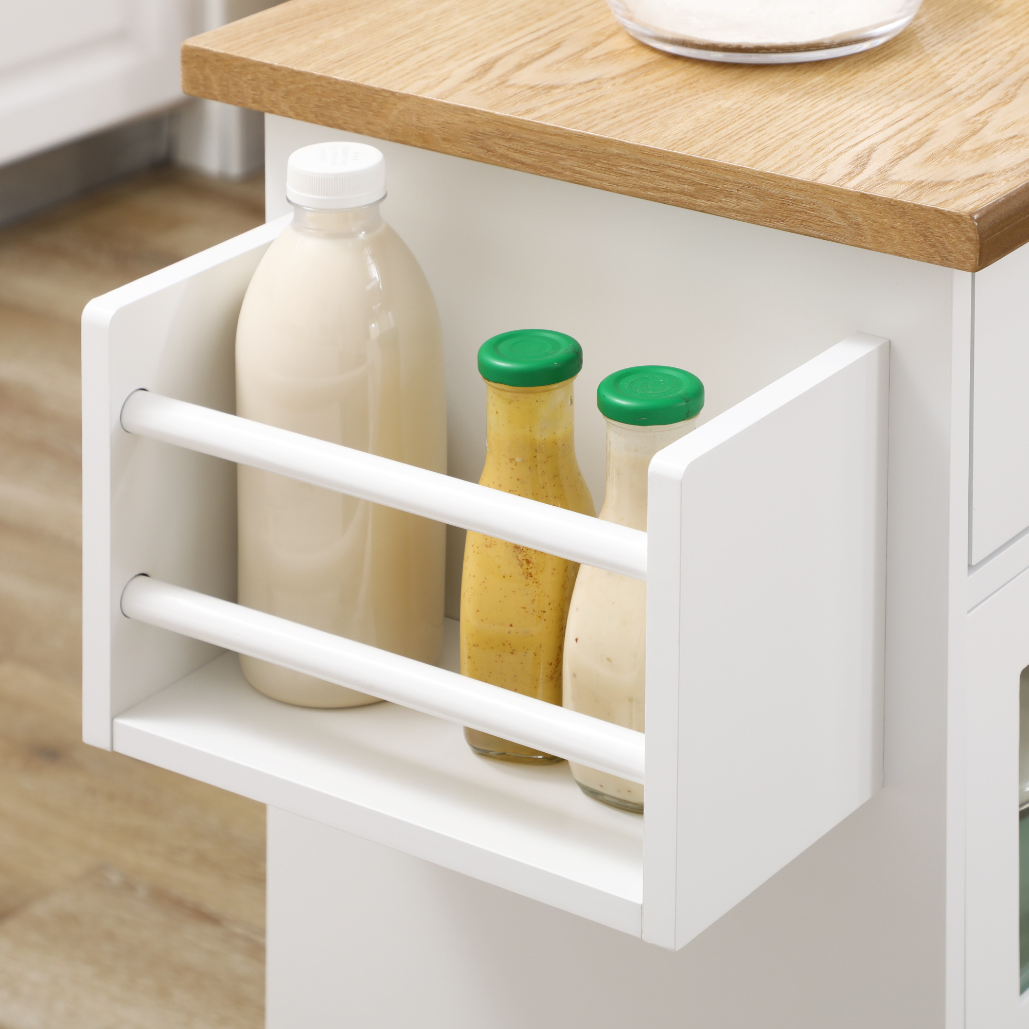 Cajón blanco con tres botellas: una botella grande de leche y dos pequeñas de mostaza.