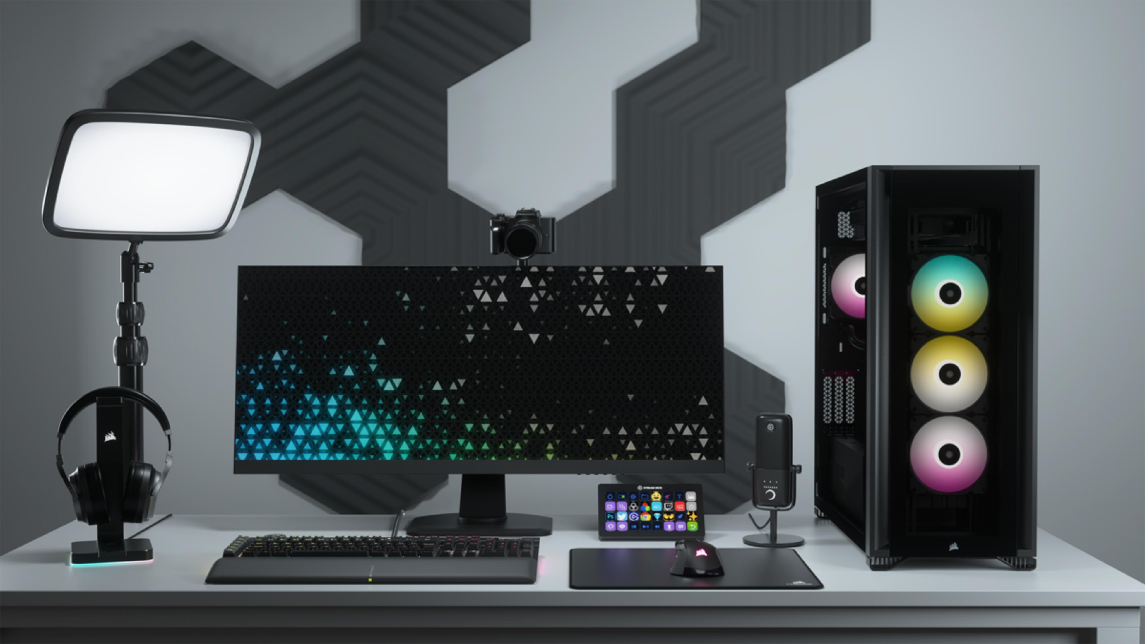 Biurko z komputerem, monitorem, klawiaturą, myszą, mikrofonem i słuchawkami.