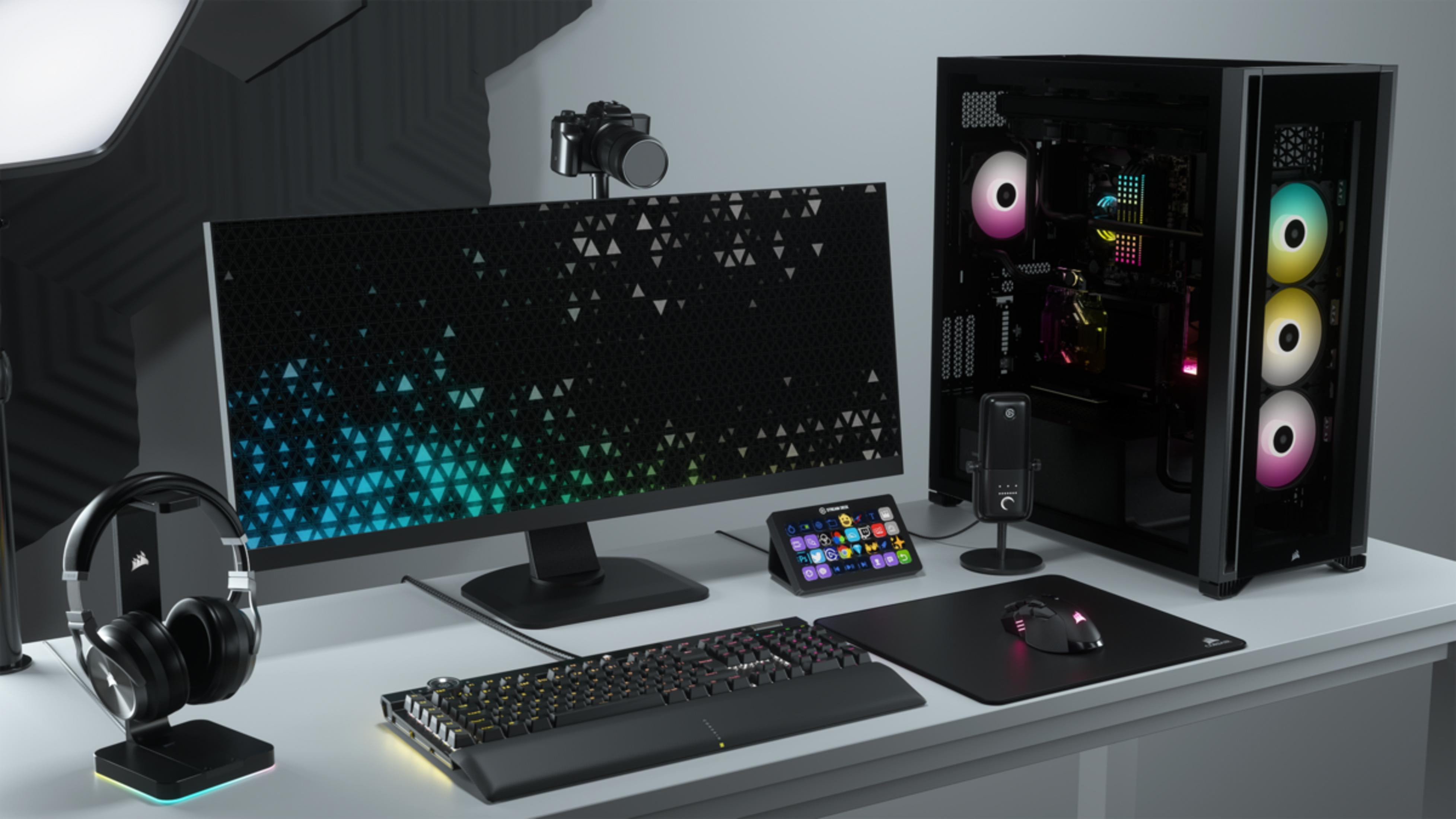 Biurko z komputerem, monitorem, klawiaturą, myszką, słuchawkami i mikrofonem.