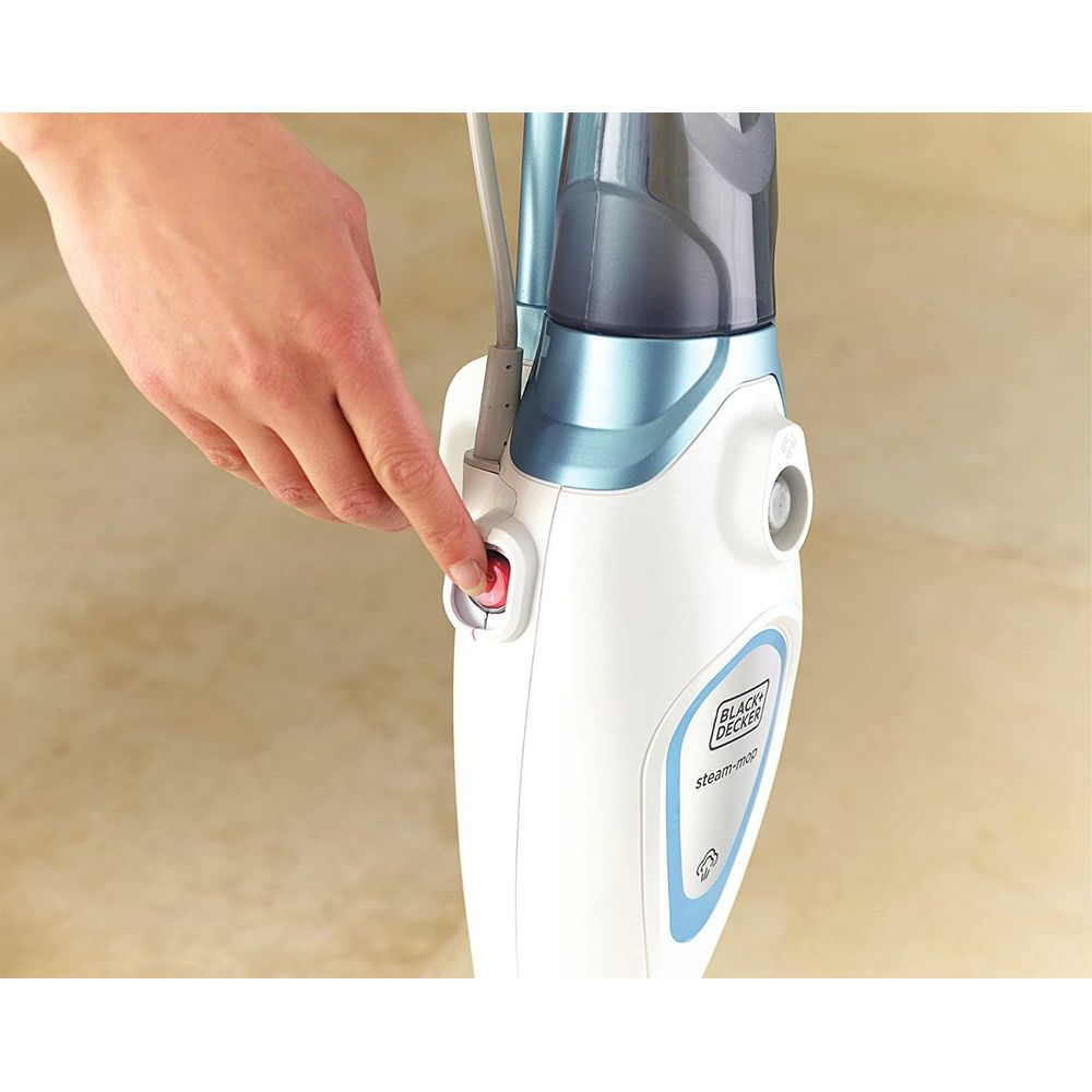 Dłoń naciska czerwony przycisk na białej parownicy z niebieskimi akcentami.