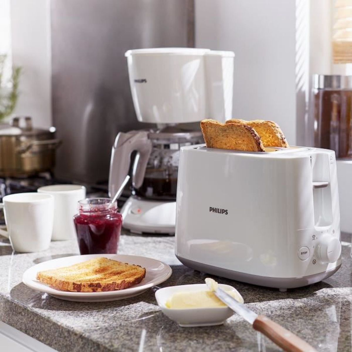 Biały toster z dwoma kromkami tostów, kawą, dżemem i masłem.