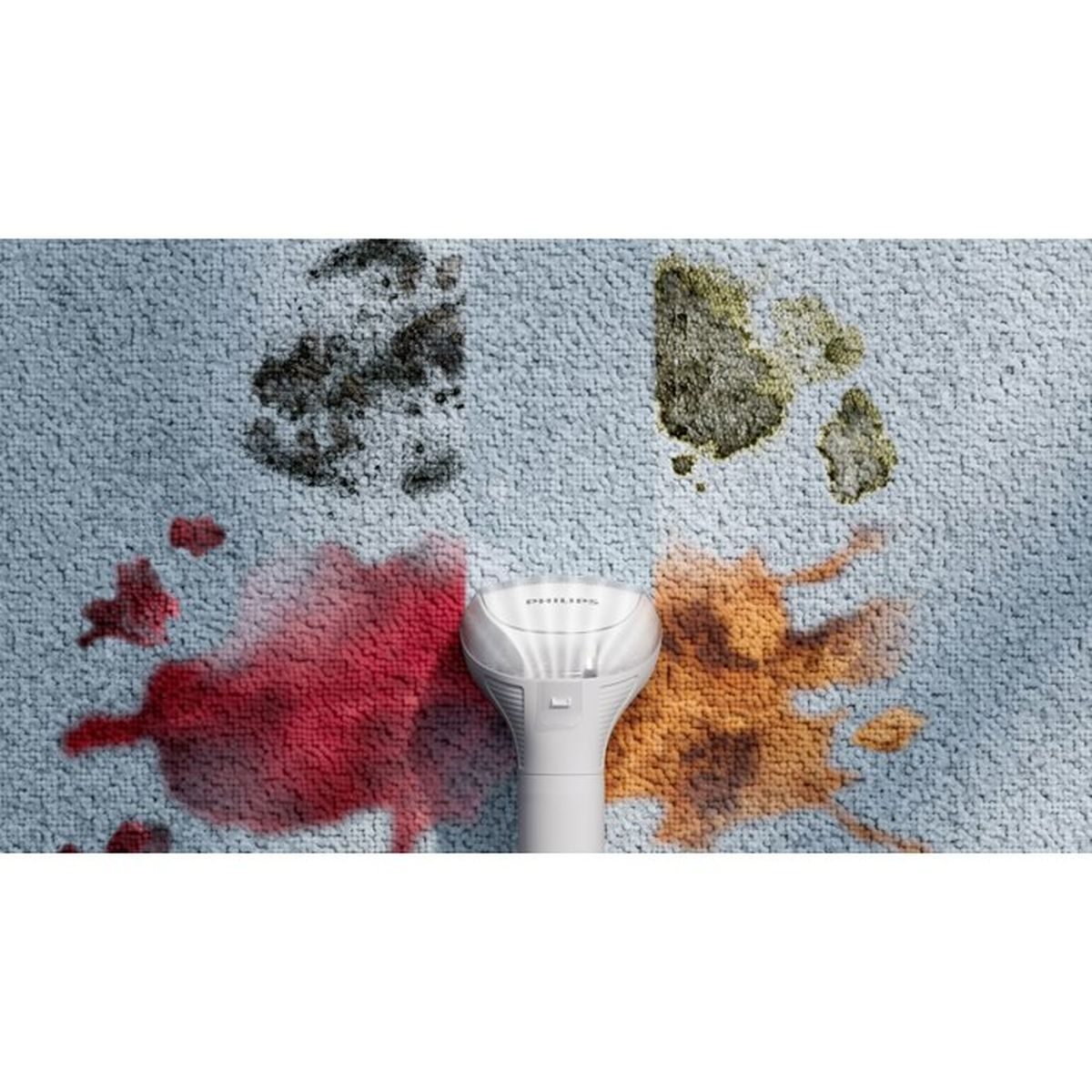 Ein weißer Reiniger auf einem hellblauen Teppich mit roten, braunen und grünen Flecken.