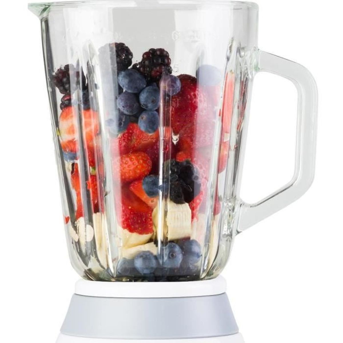 Jarra de licuadora de vidrio llena de fresas, arándanos, moras y trozos de plátano.