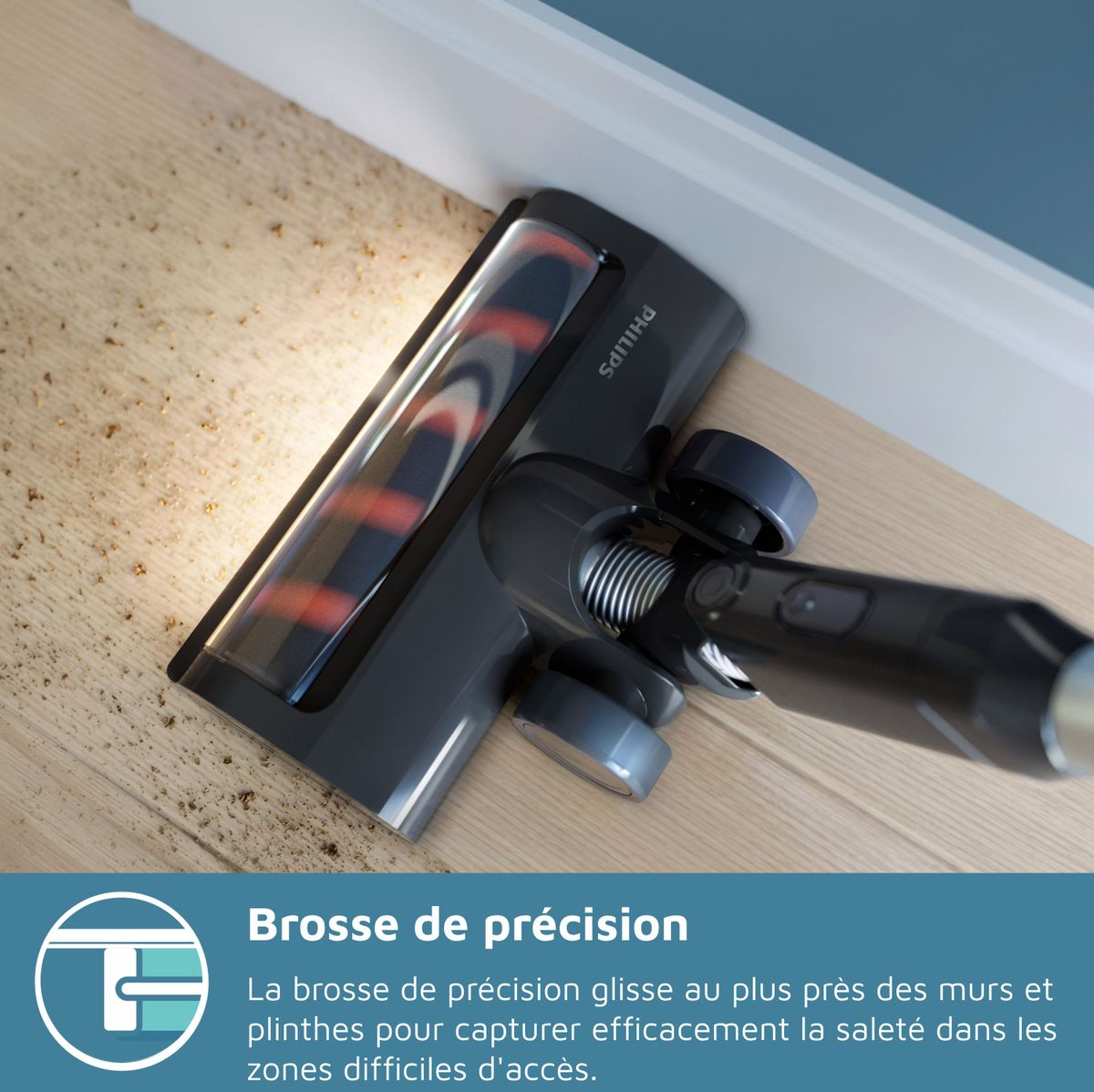 Cabezal de aspiradora gris oscuro limpia suelo de madera cerca de pared.