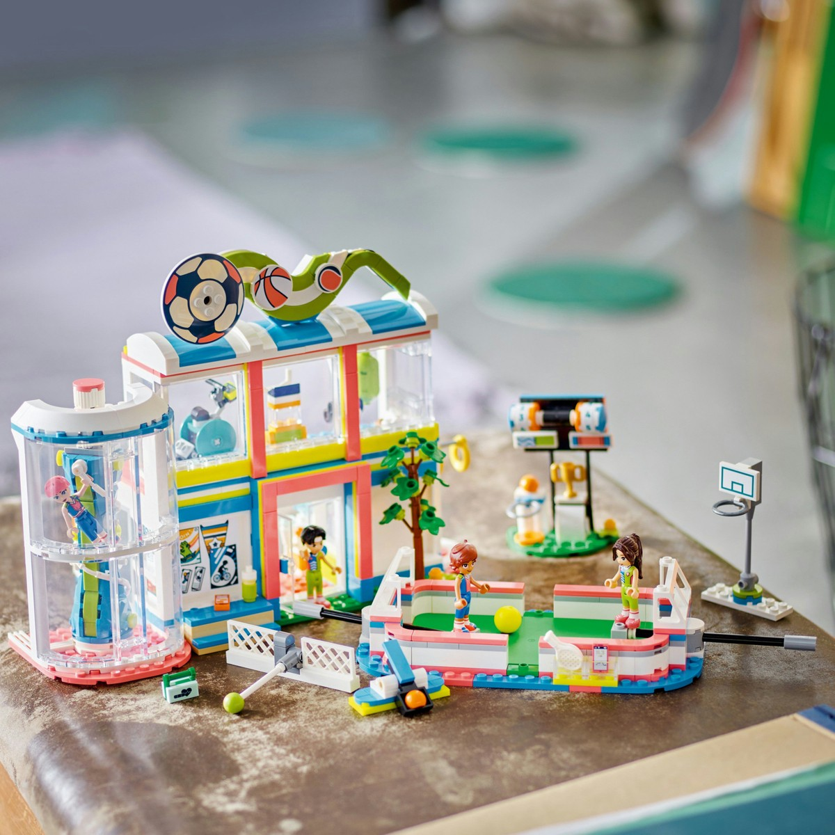 Figürler, futbol kalesi, basketbol potası ile renkli Lego spor merkezi.