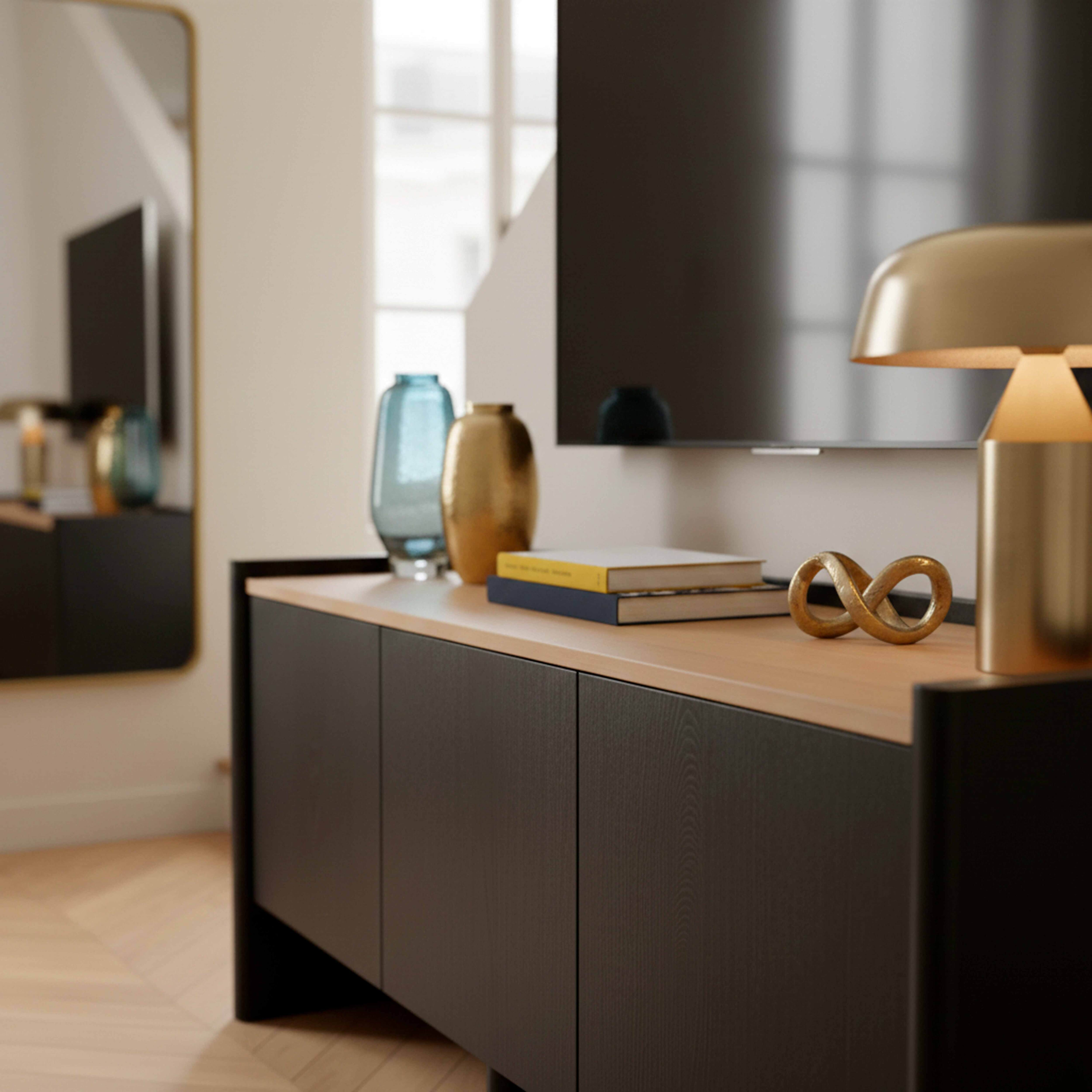 Ein moderner Wohnzimmerschrank mit zwei Vasen, Büchern und einer Lampe.