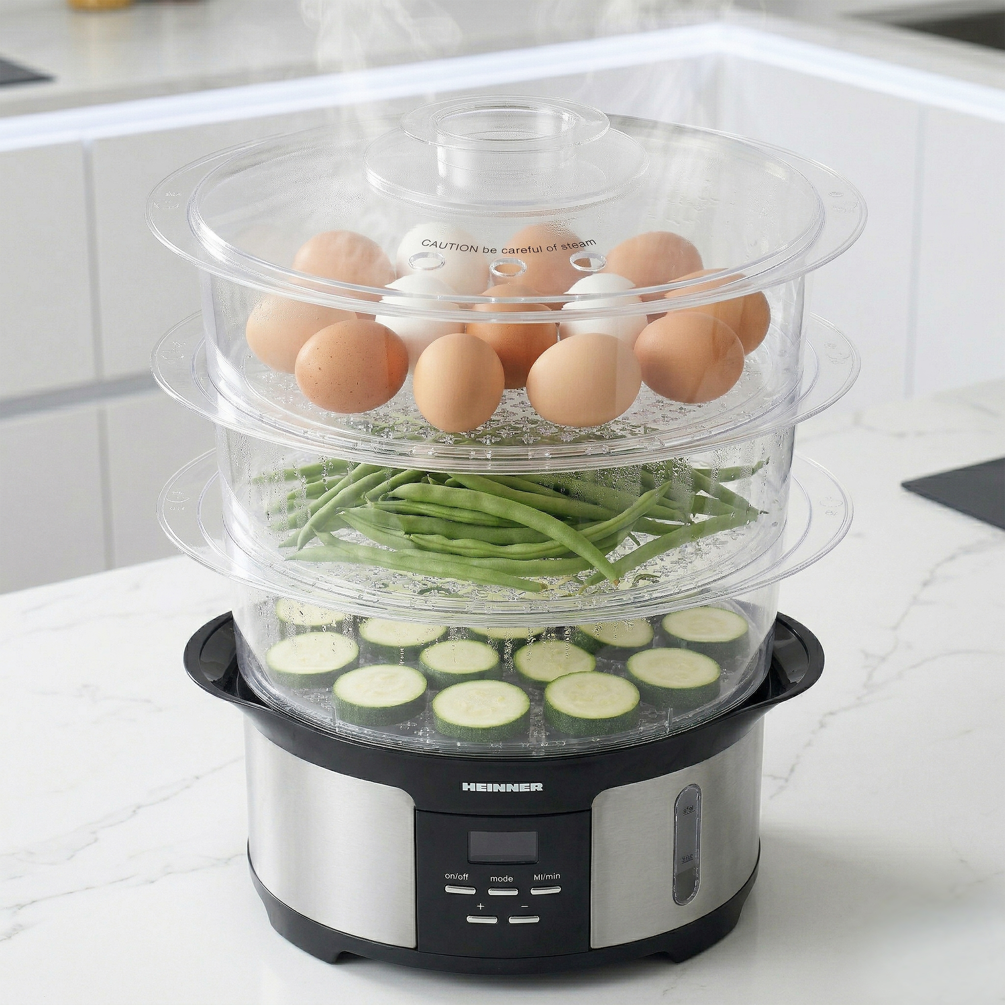 A food steamer with eggs, green beans, and zucchini slices.
