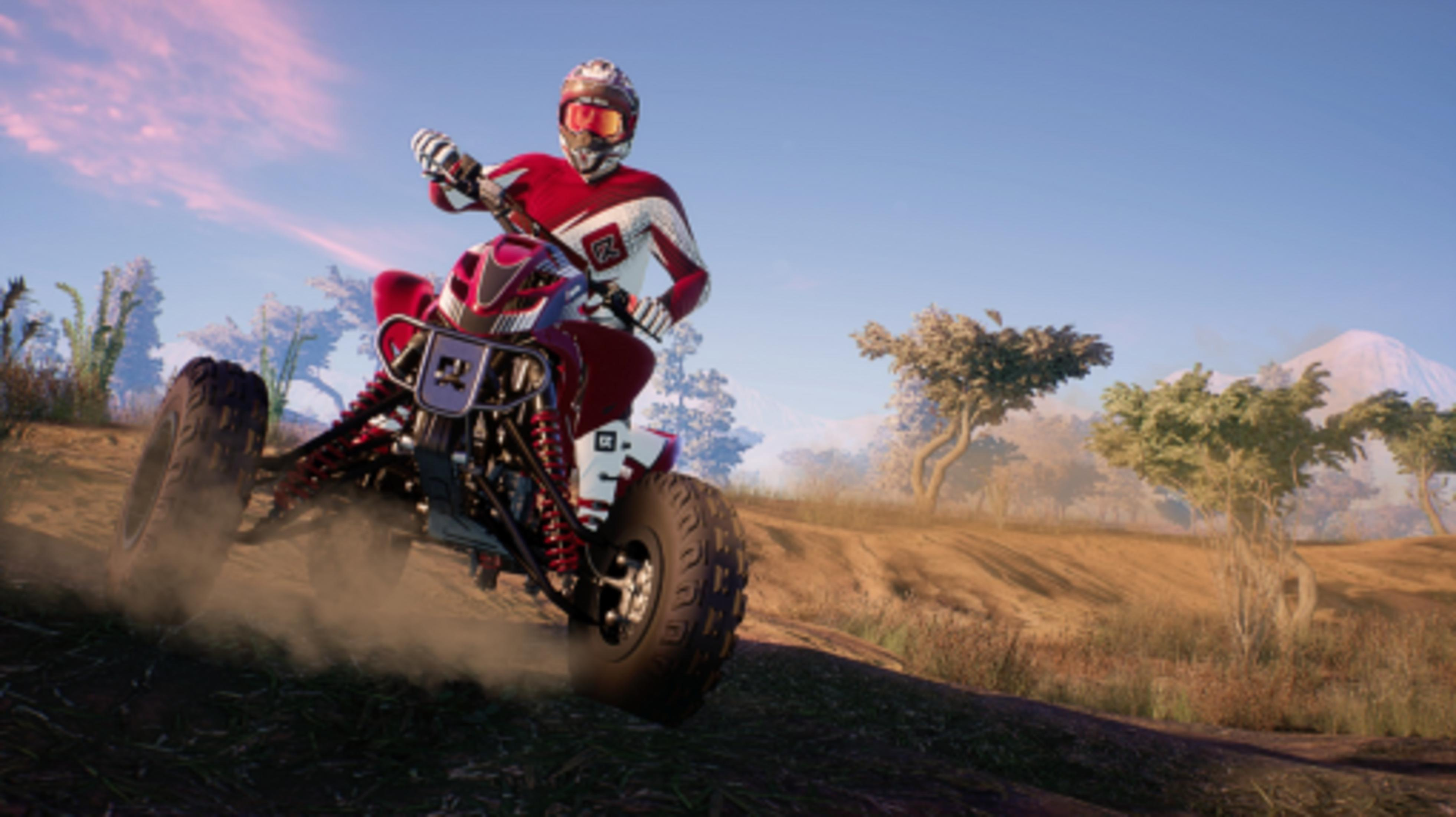 Ein Fahrer auf einem roten Quad fährt staubig über einen Feldweg.