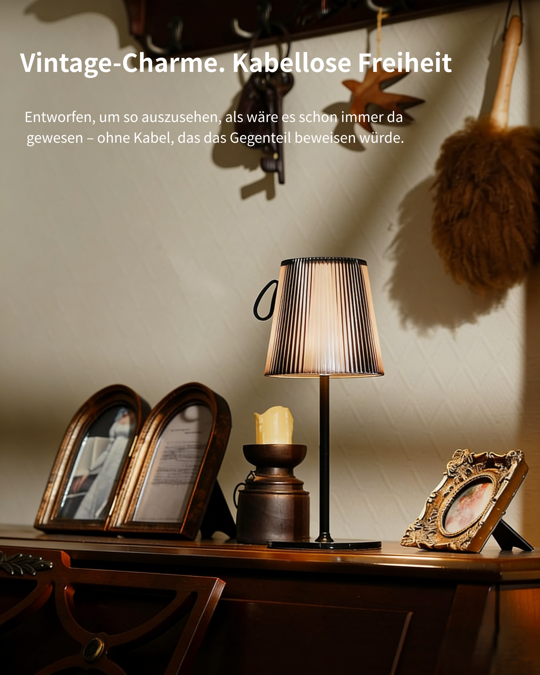 Eine Lampe mit Falten-Schirm steht auf einem Tisch mit Bilderrahmen.