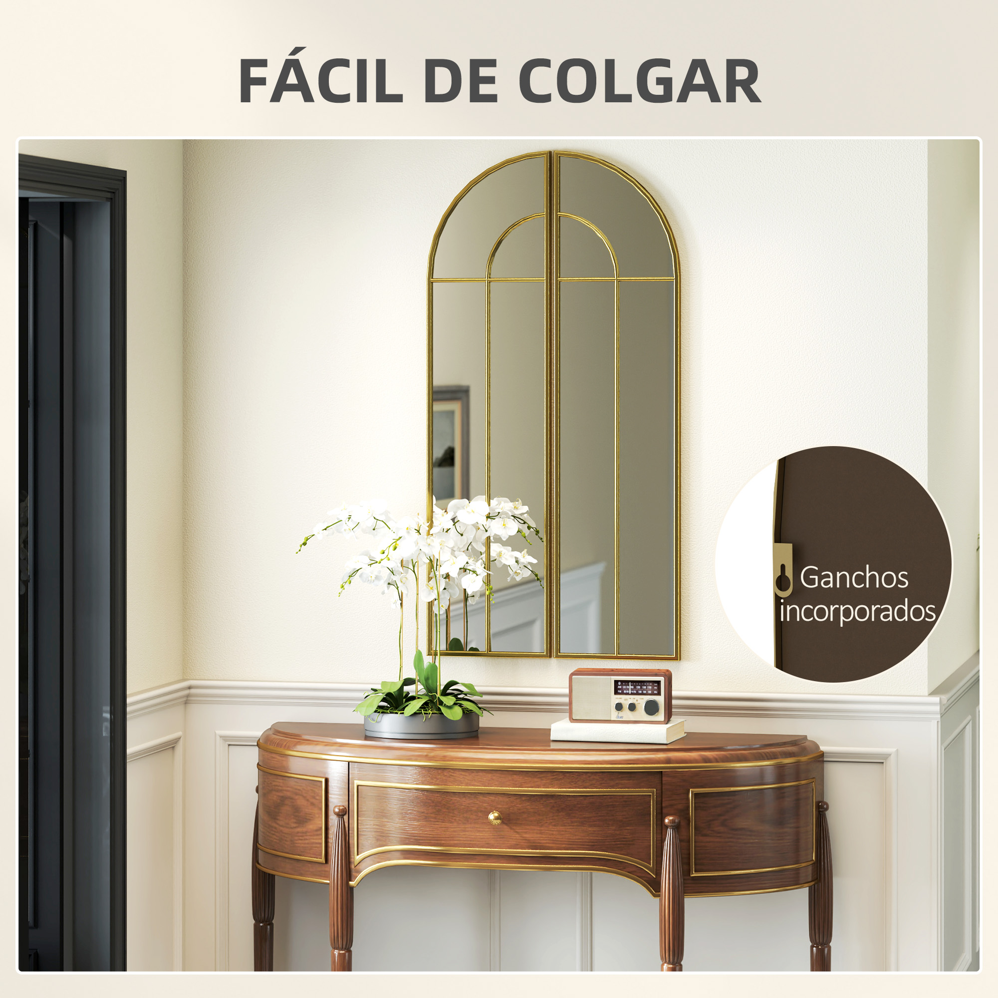 Un espejo dorado sobre consola con radio y flores.