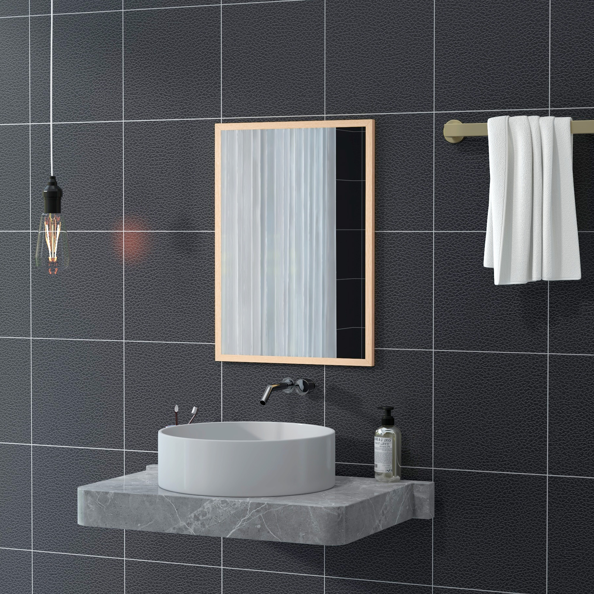 Un baño moderno con azulejos oscuros, mostrador de mármol, lavabo y espejo.