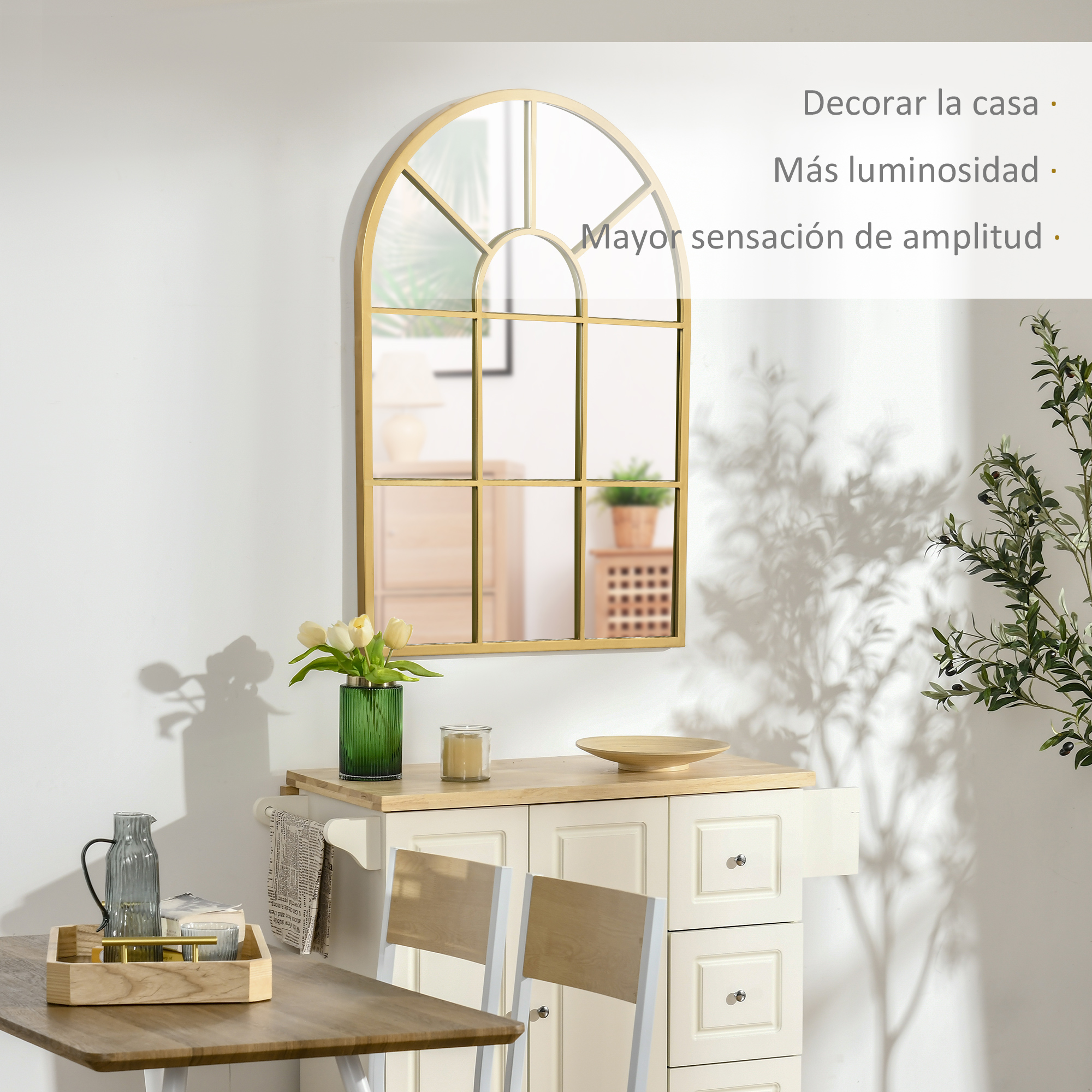 Un espejo dorado arqueado cuelga sobre un mueble crema con tulipas.