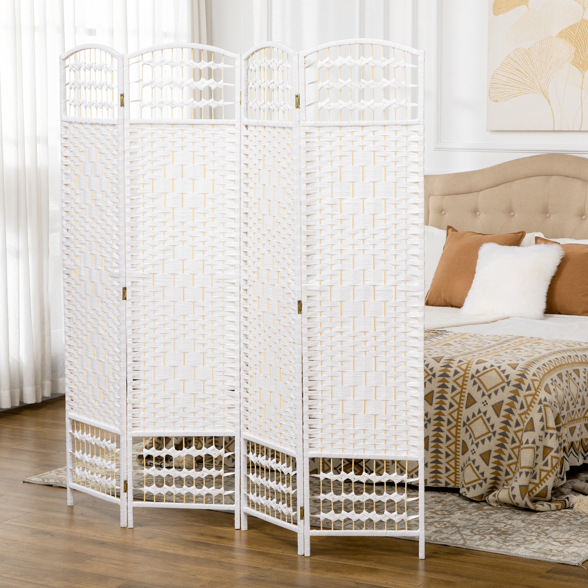 Un separador de ambientes blanco de 4 paneles se alza ante una cama con almohadas marrones.
