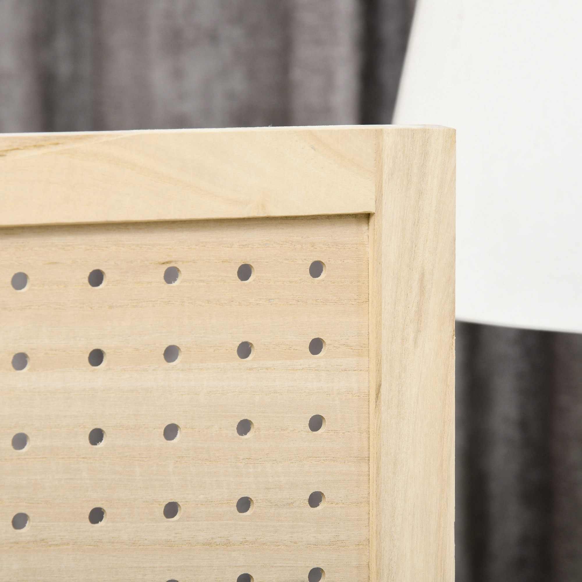 Un primer plano de un tablero de clavijas de madera con múltiples agujeros.