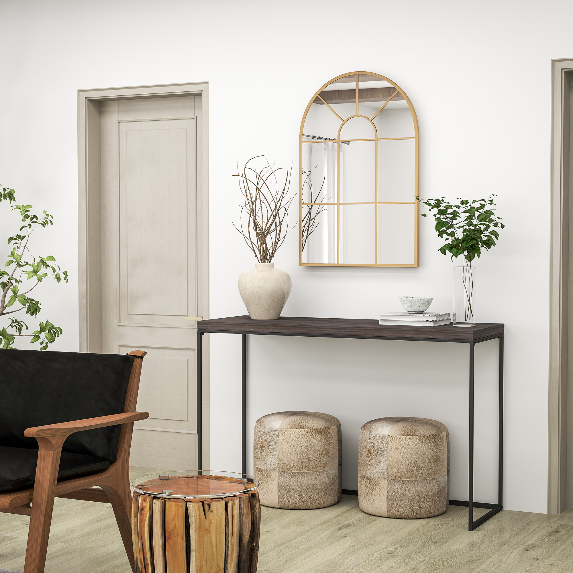 Una habitación luminosa con suelo de madera, sillón negro, mesa consola y dos taburetes.