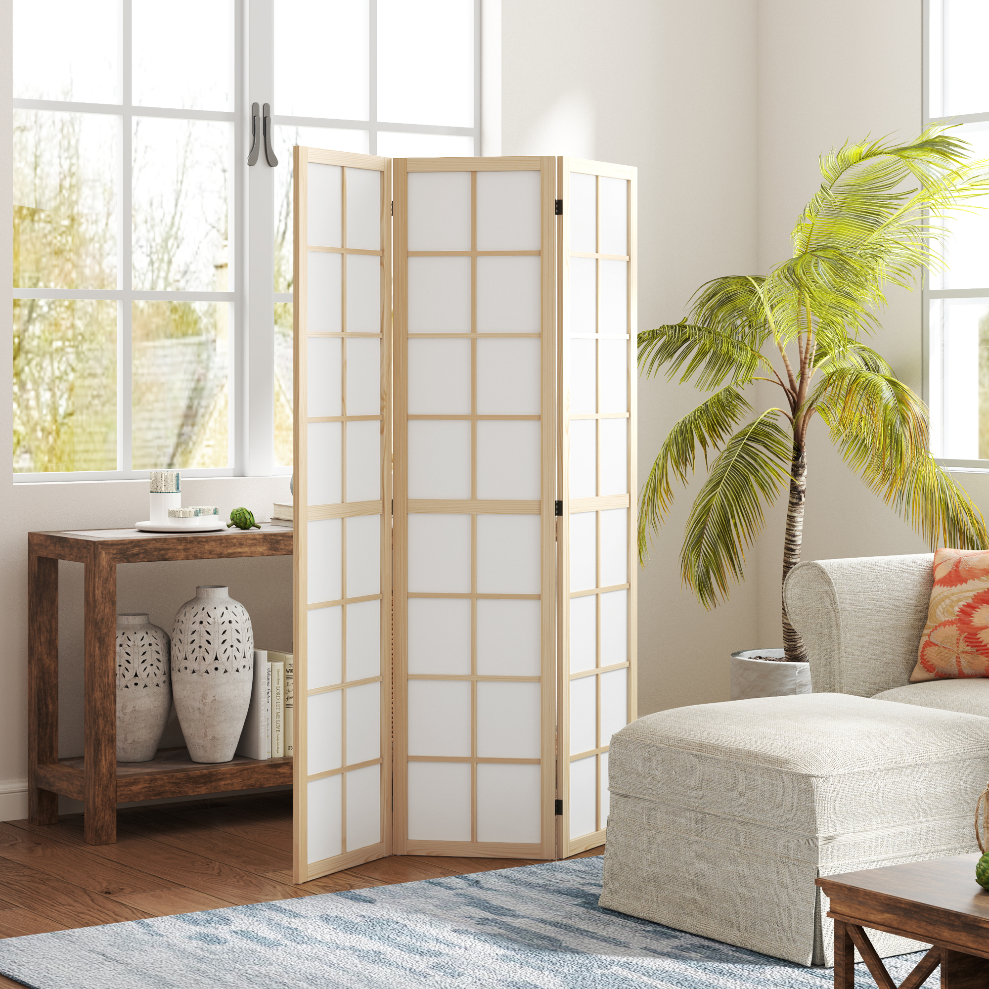 Un separador de ambientes de madera y papel junto a un sofá y una palmera.
