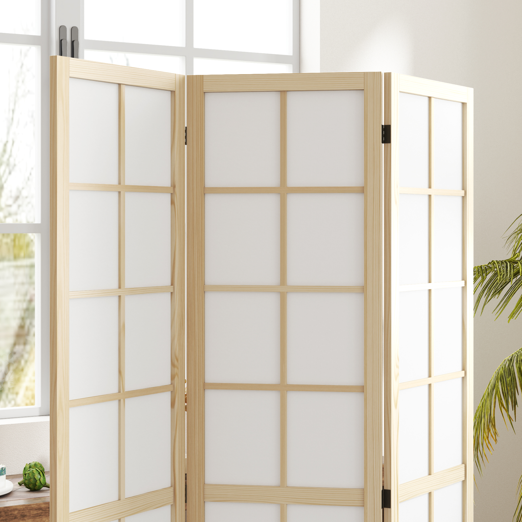 Un biombo de tres paneles de madera clara con paneles blancos, junto a una ventana.