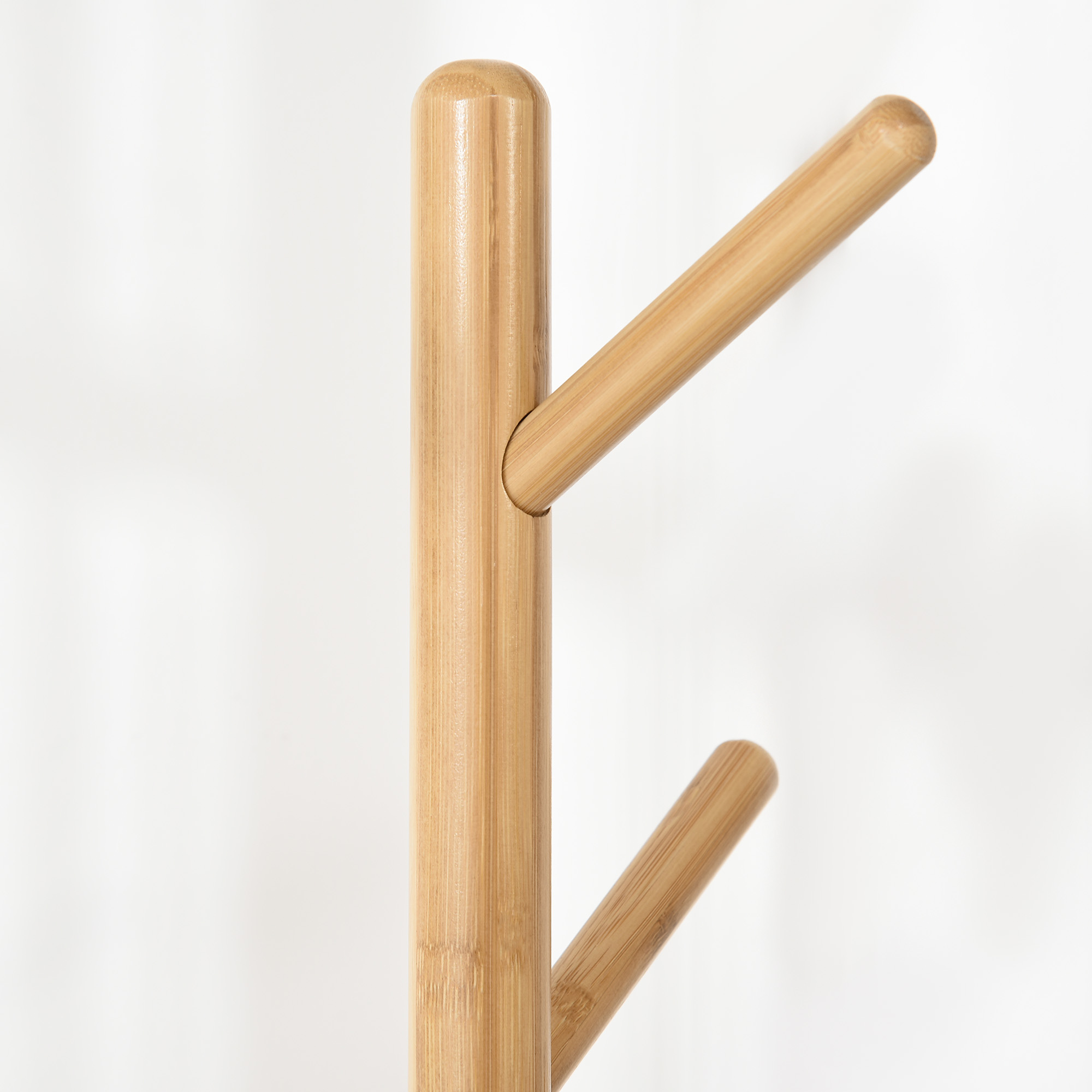 Una percha de madera con ganchos redondeados sobre fondo blanco.