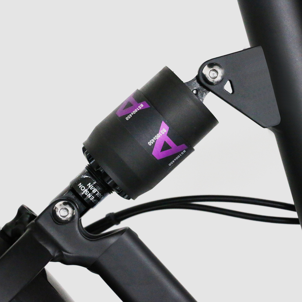 Czarny amortyzator rowerowy z fioletowym logo i specyfikacjami.