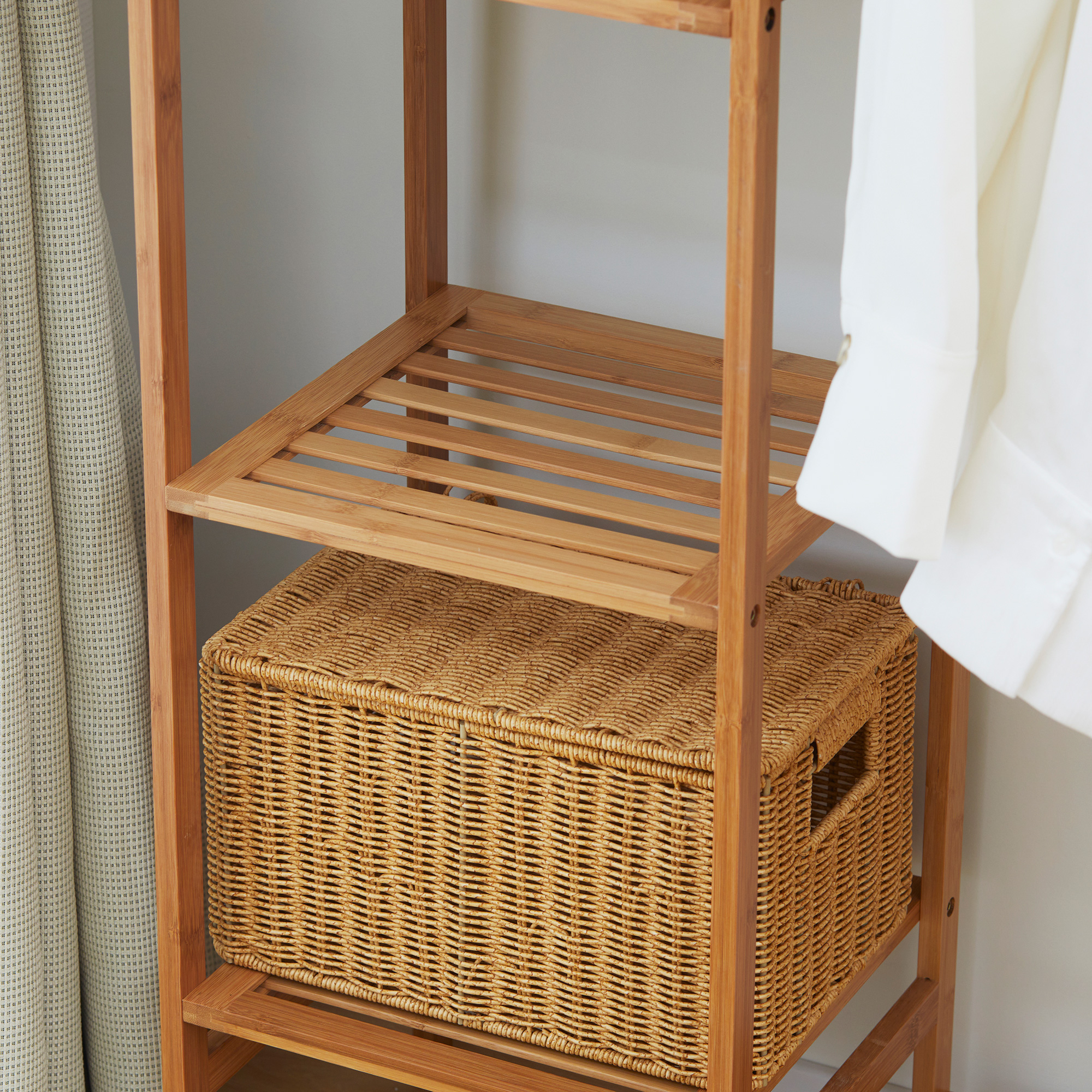Un estante de madera con una cesta tejida y ropa.