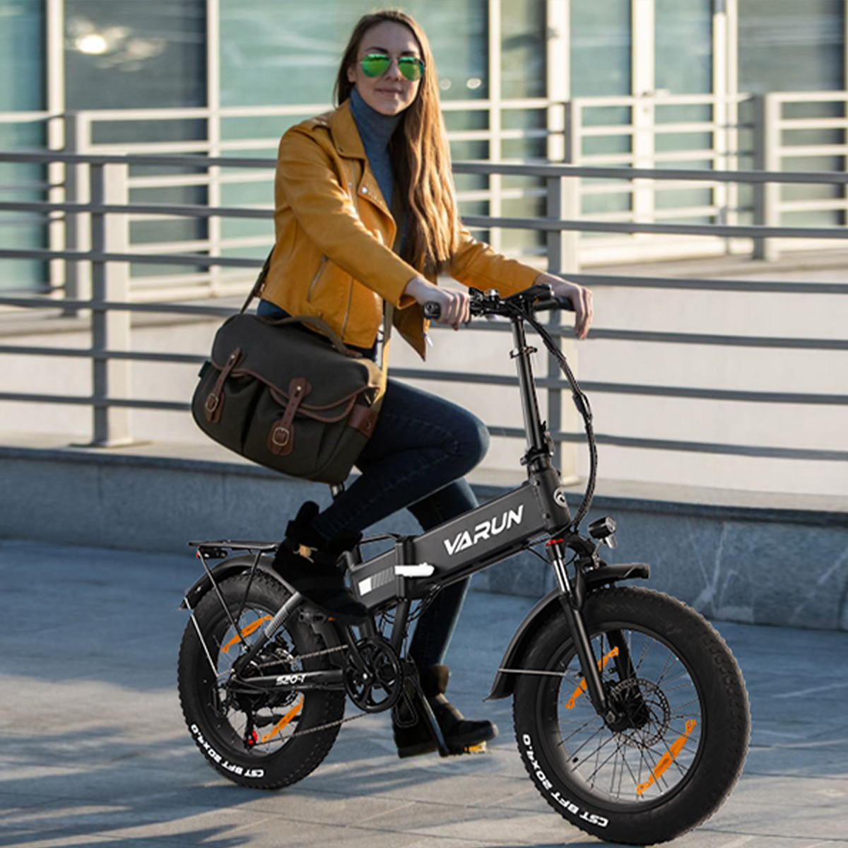 Kobieta w żółtej kurtce jedzie na rowerze elektrycznym z grubymi oponami.