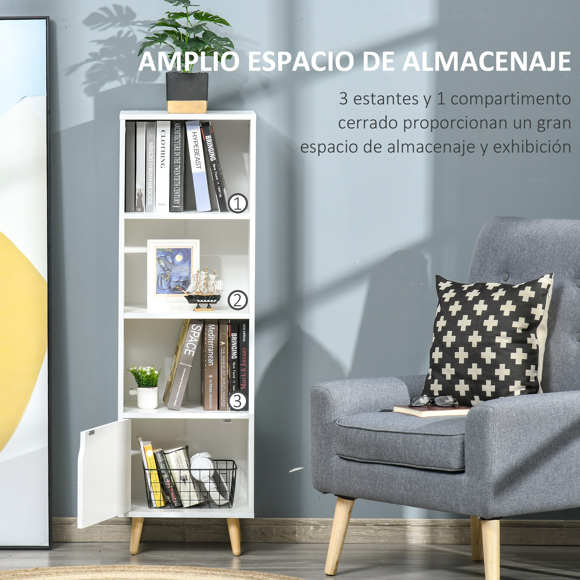 Una estantería blanca con libros, un cuadro y una planta junto a un sillón.