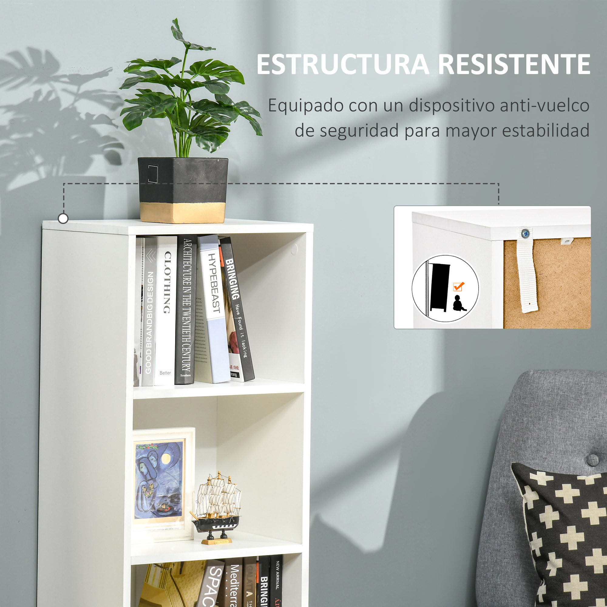 Un estante blanco con libros, una planta y un sillón gris.