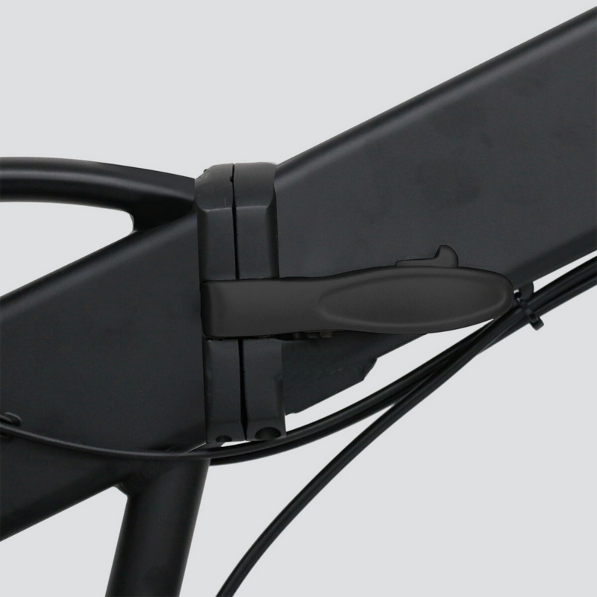 Zbliżenie na czarny zawias ramy roweru z dźwignią blokującą i kablami.