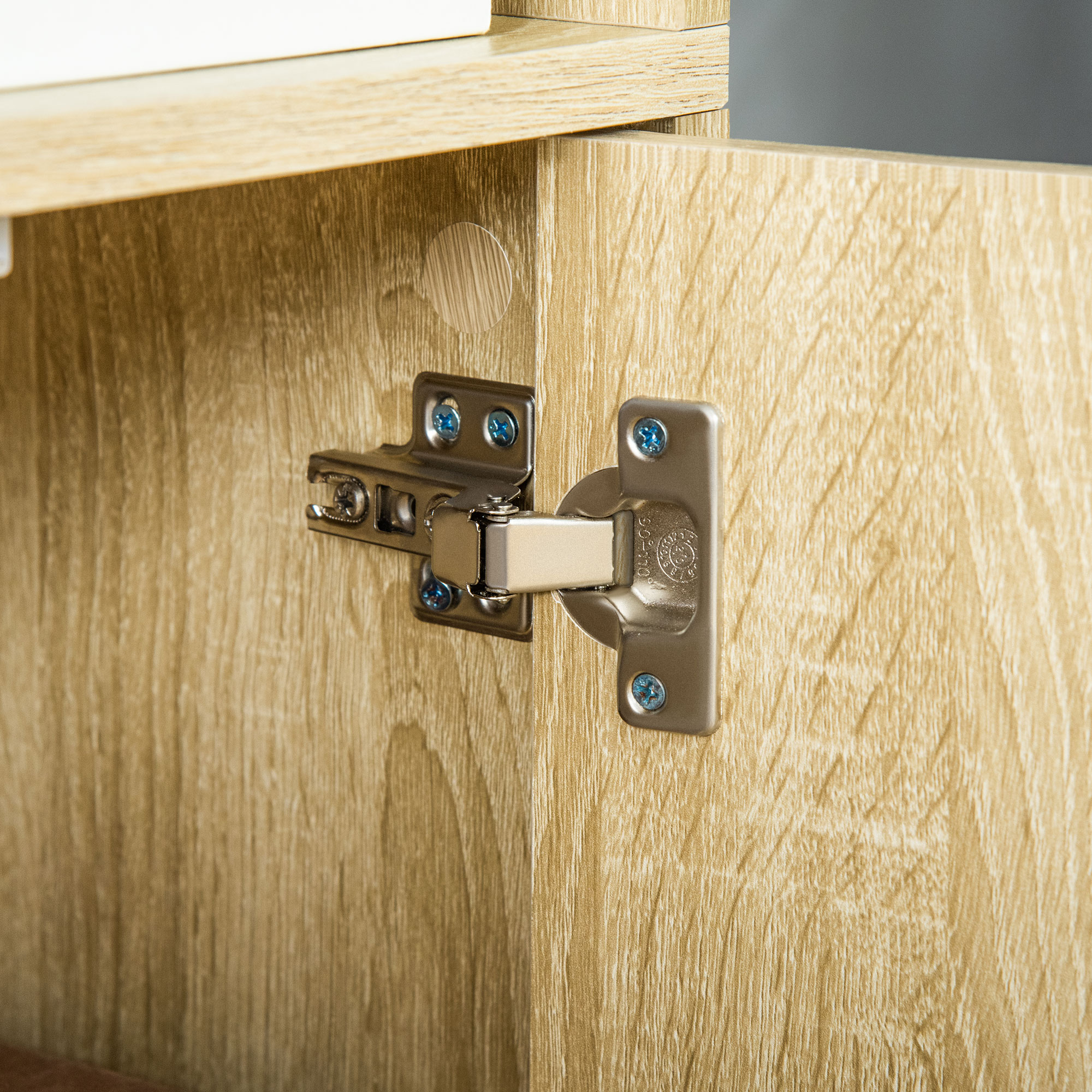 Una bisagra de metal con tornillos azules en una puerta de madera.