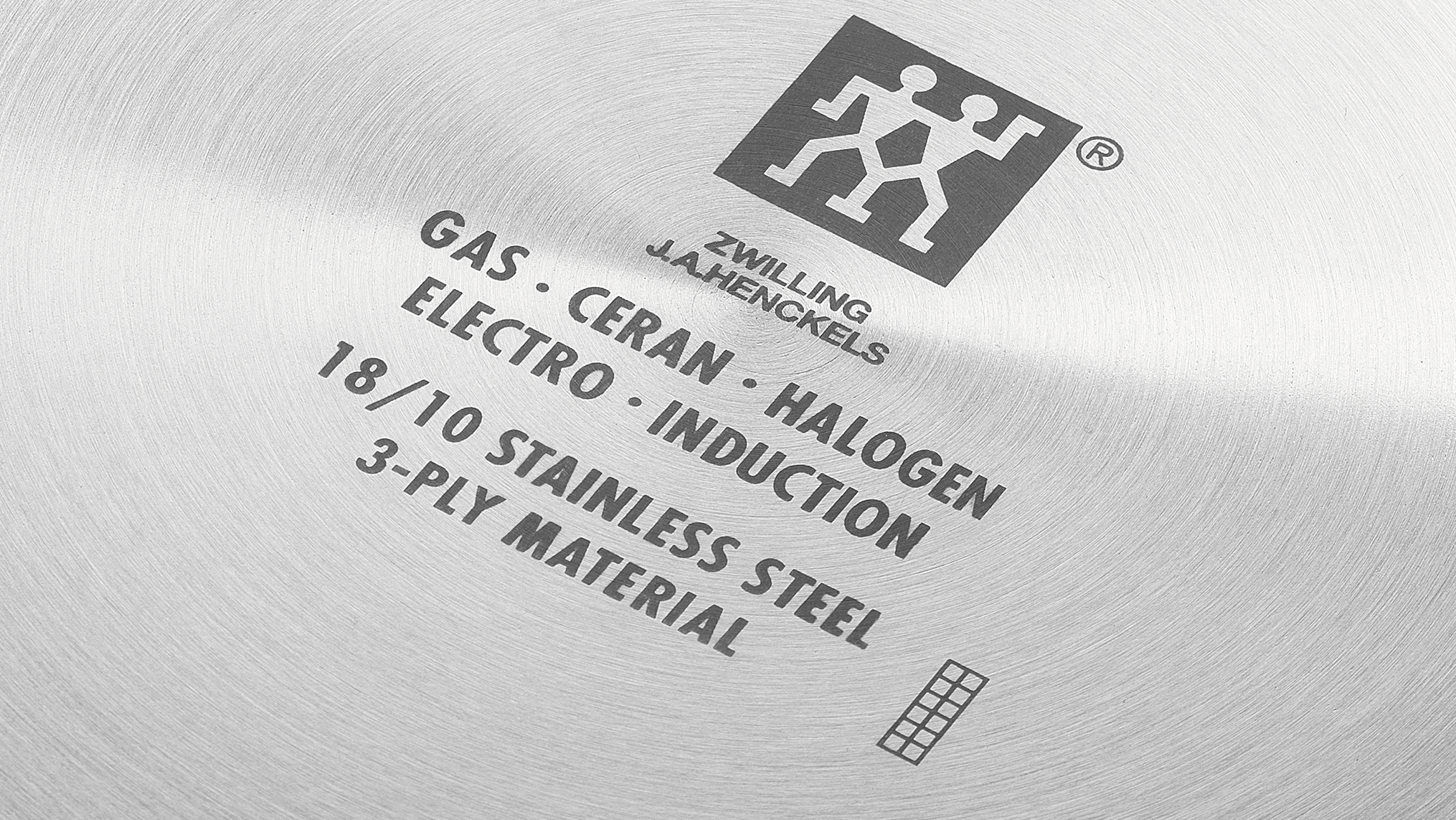Detailaufnahme eines Topfes mit Aufschriften für Gas, Ceran, Halogen, Elektro, Induktion, 18/10 Edelstahl, 3-Lagen-Material.
